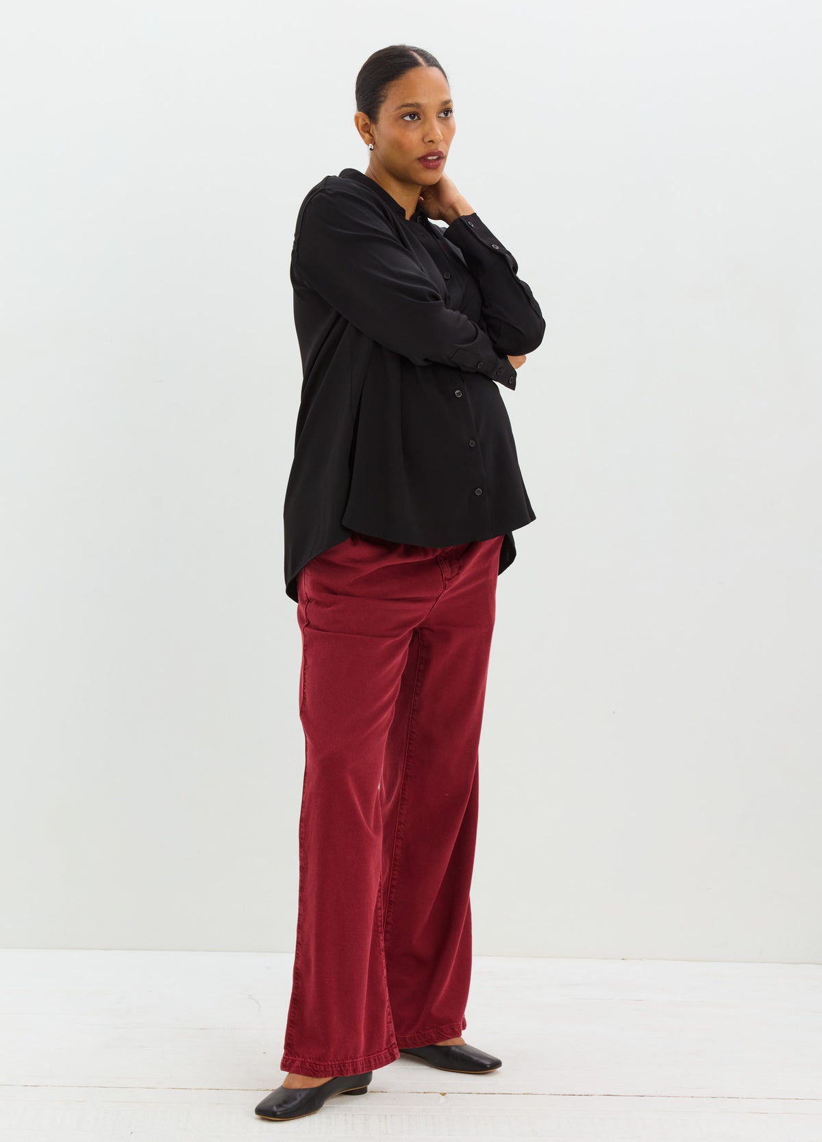 Black drapey button-down shirt with a relaxed fit, paired with burgundy wide-leg trousers.