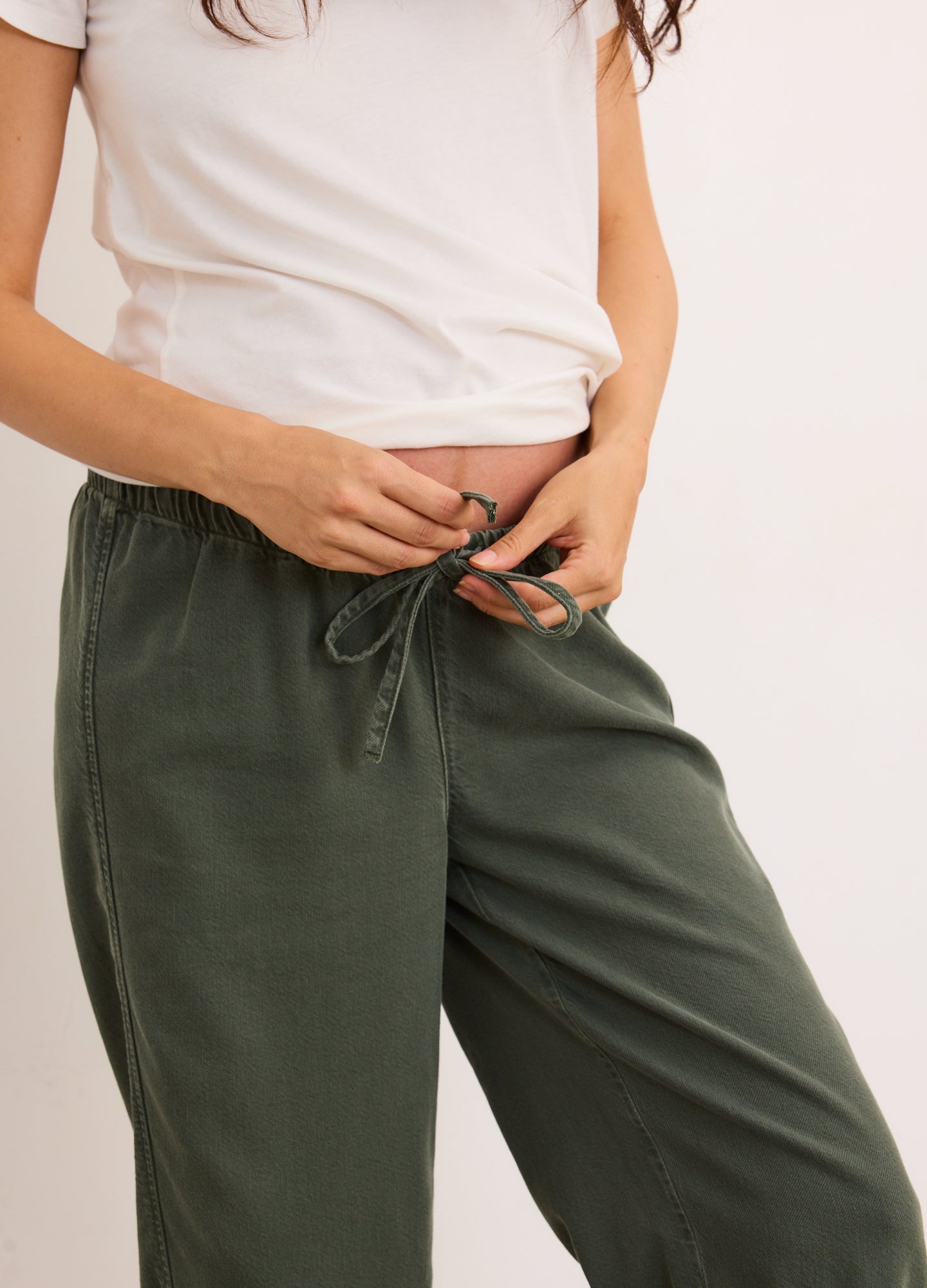 Olive green maternity denim barrel pants with adjustable drawstring waist and relaxed fit.