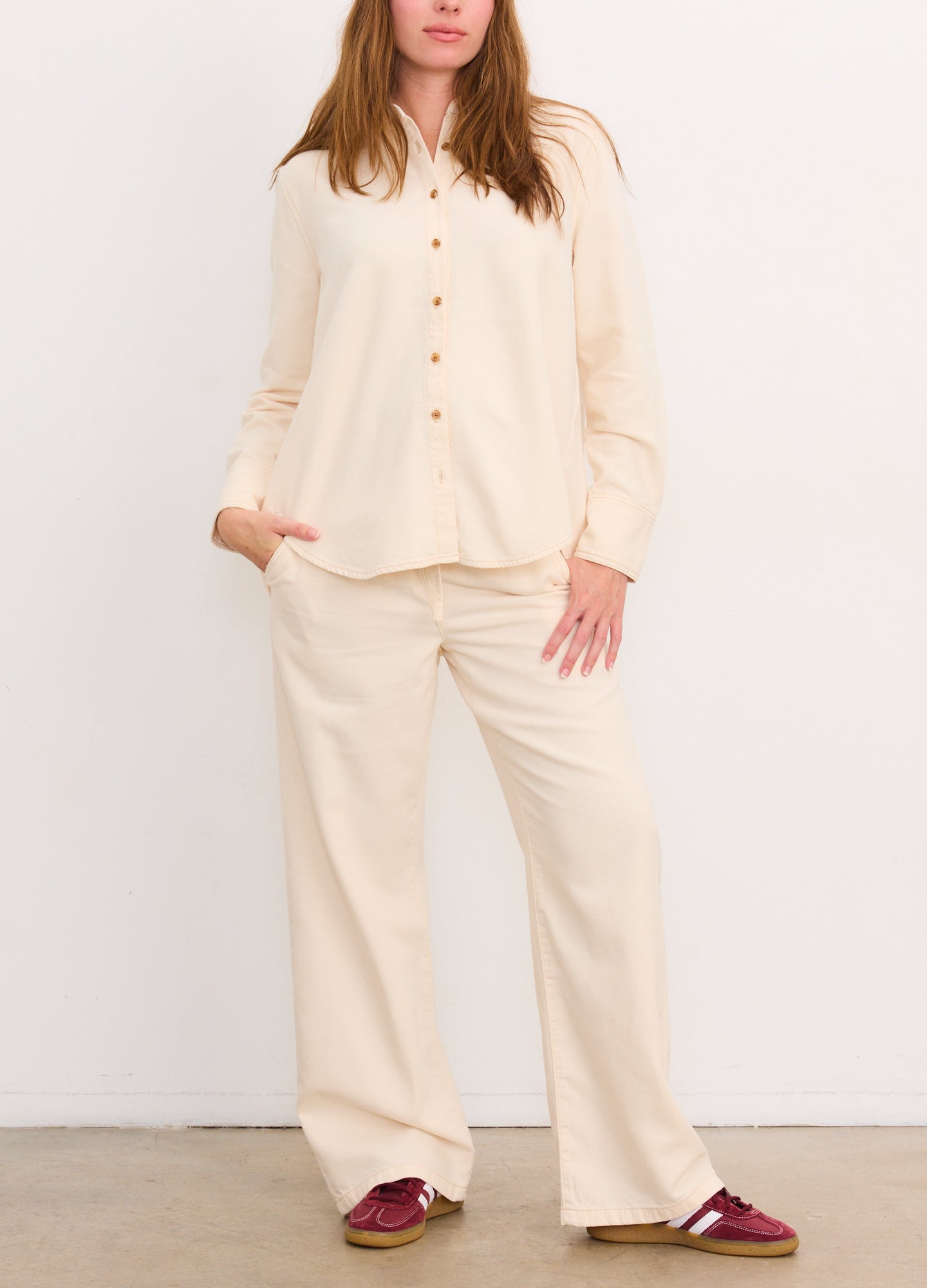 Cream drapey boyfriend shirt with buttons, relaxed fit maternity top paired with matching wide-leg pants.