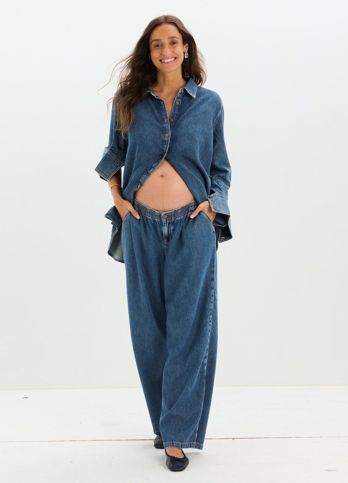 Dark blue loose-fit maternity denim pants with elastic waistband, paired with matching denim shirt.
