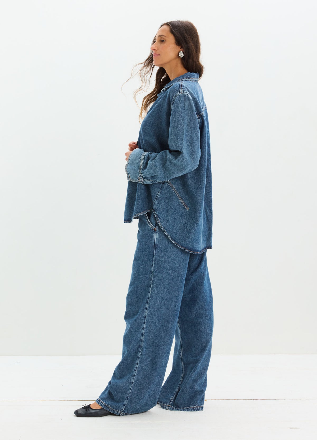 Dark blue wide-leg maternity denim pants with relaxed fit and high waist panel, styled with matching loose denim shirt and.
