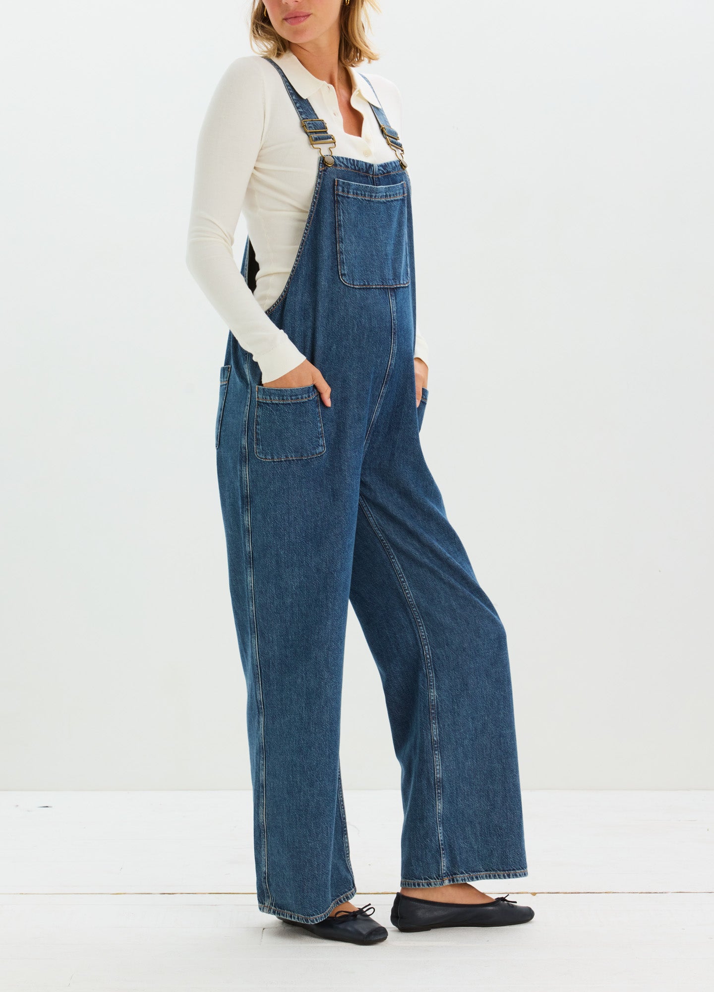 Blue maternity denim overalls with wide legs, front bib pocket, and adjustable shoulder straps.