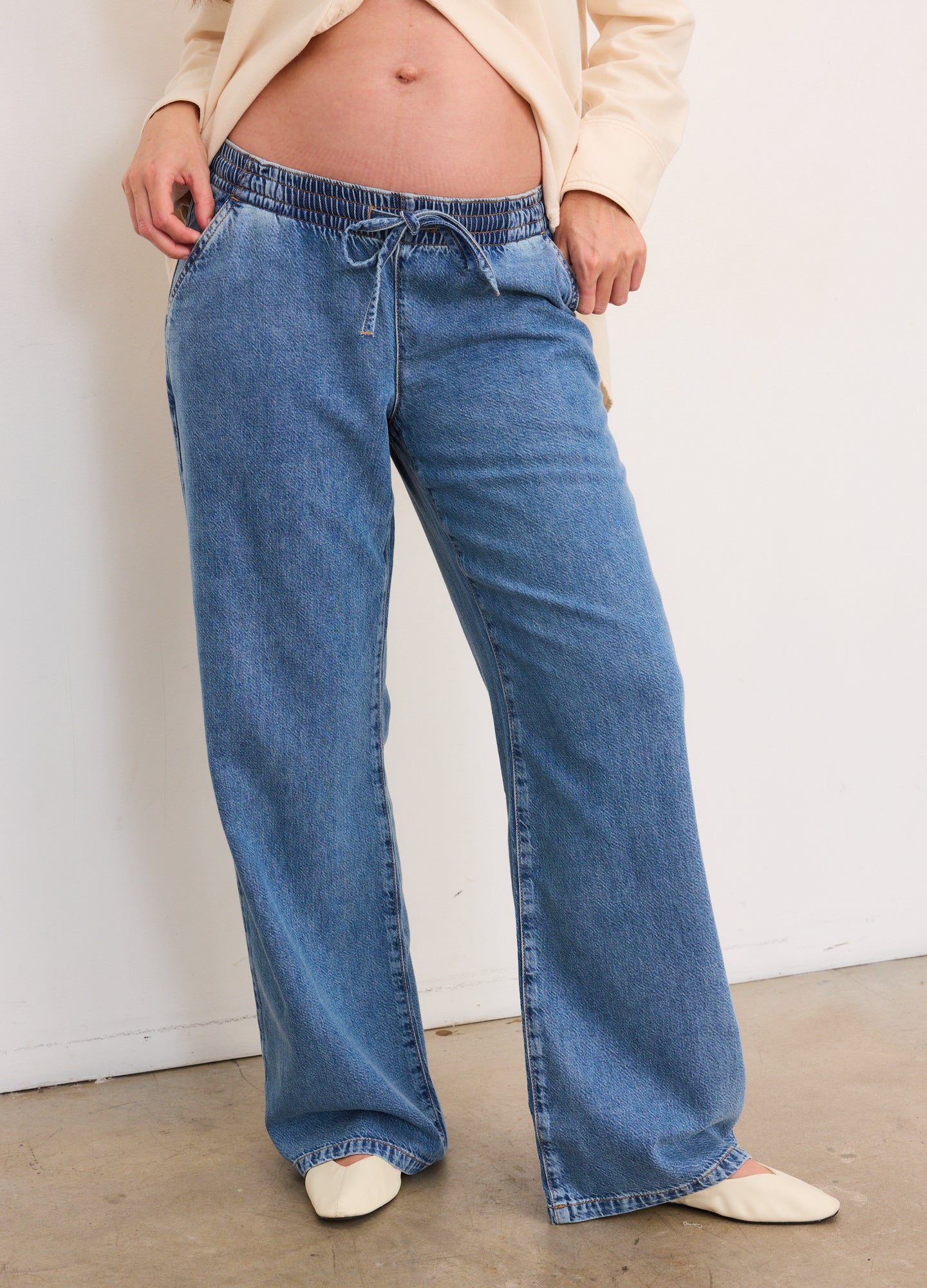 Blue wide-leg maternity denim pants with adjustable drawstring waist and relaxed fit.