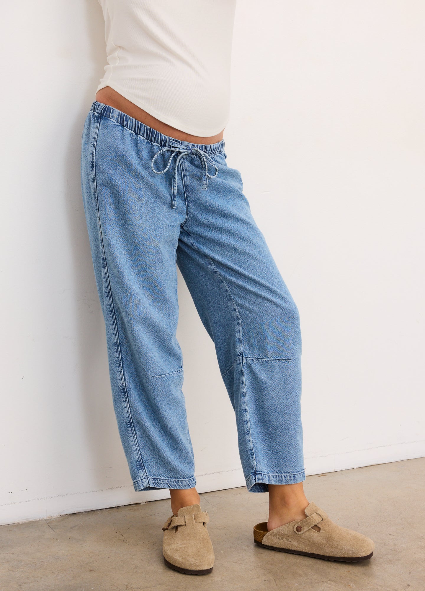 Light blue maternity denim barrel pants with elastic waistband and drawstring, relaxed fit, cropped length.