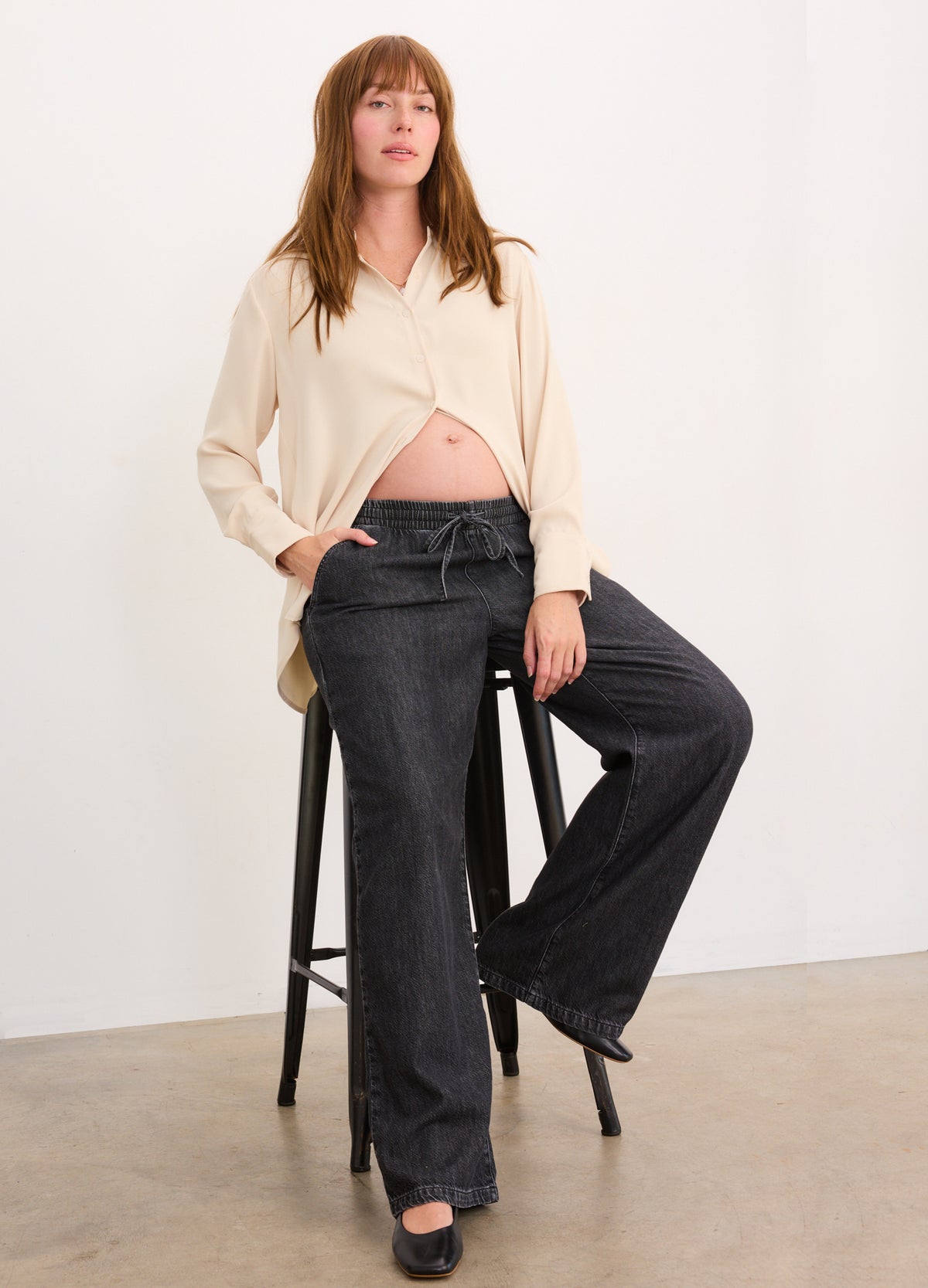 Black wide-leg denim pants with a relaxed fit, designed for maternity wear.
