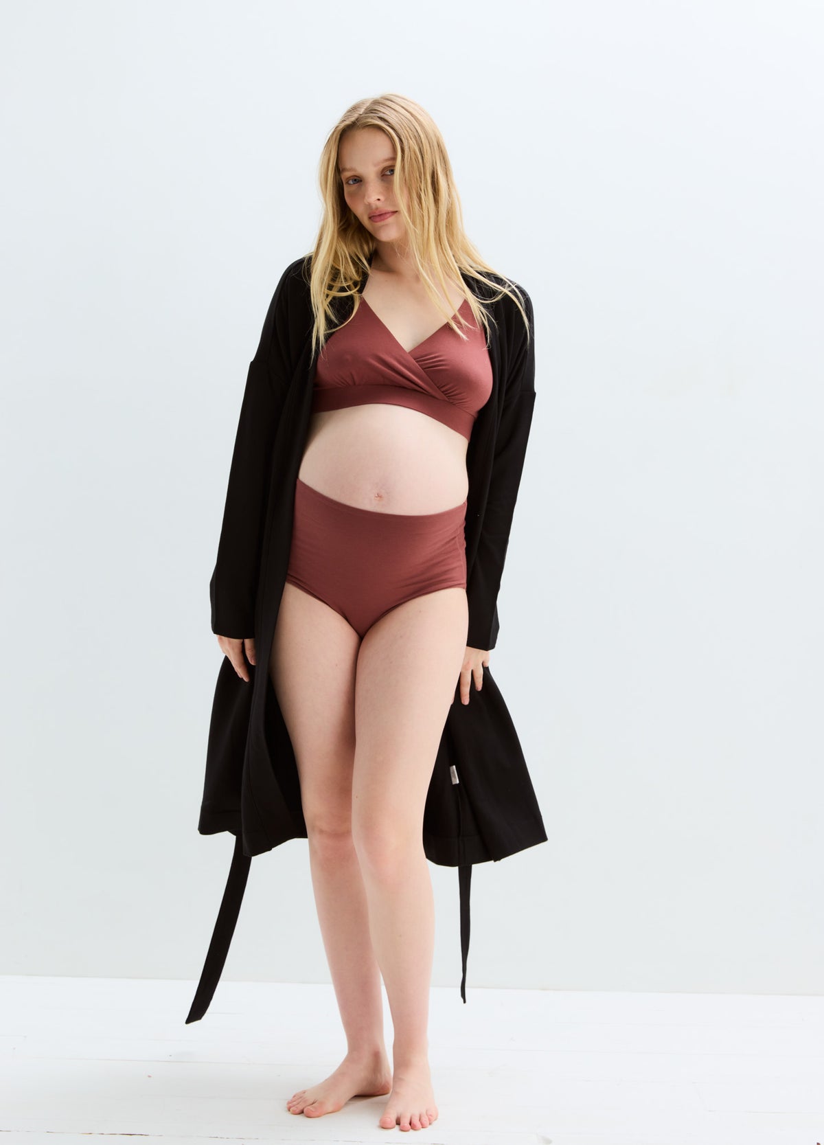 Maternity nursing bra and matching high-waist briefs in soft dusty rose, seamless fabric with supportive wrap-front design.