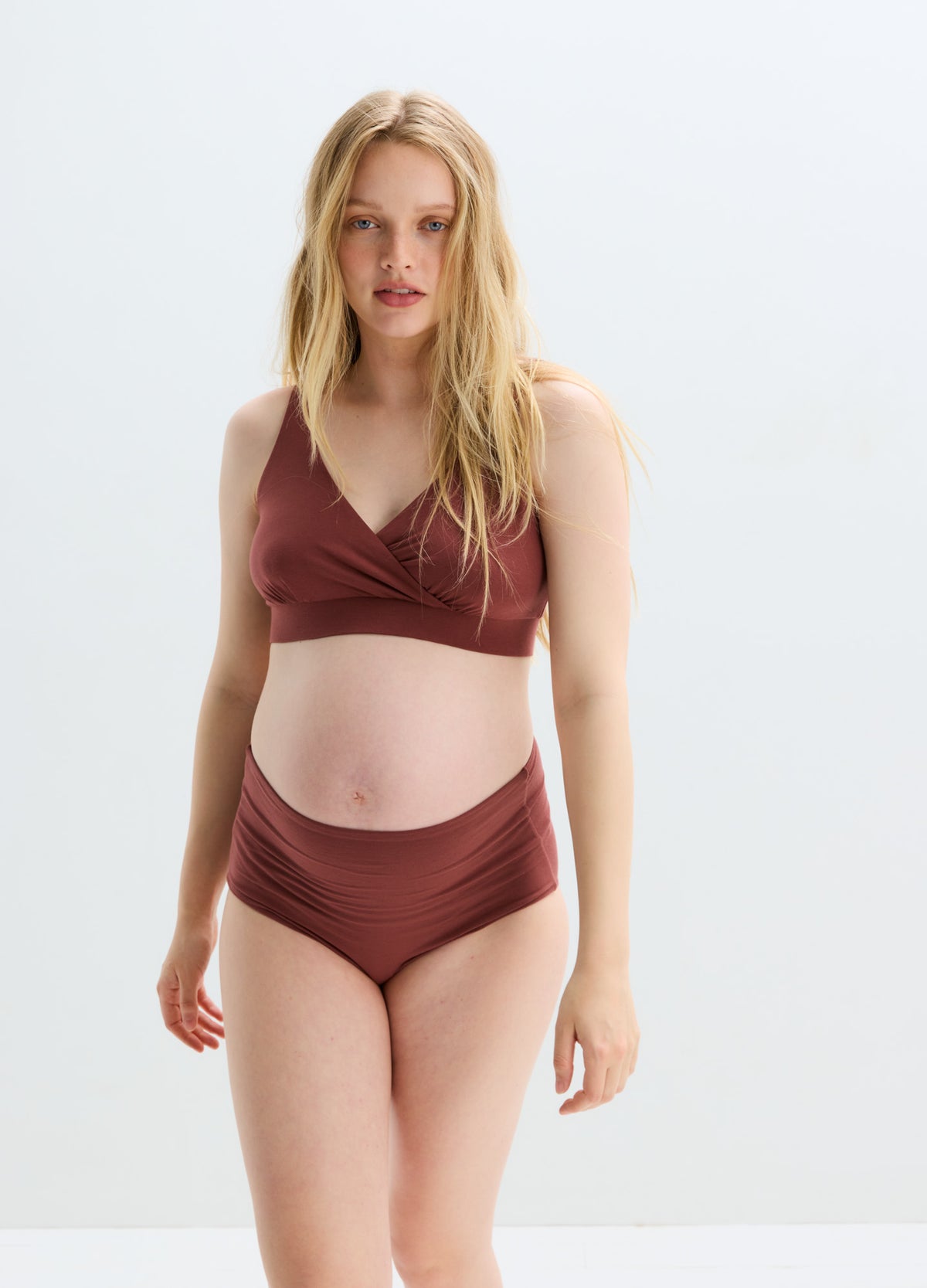 Soft brown maternity nursing bra with wide straps and seamless design on pregnant model.