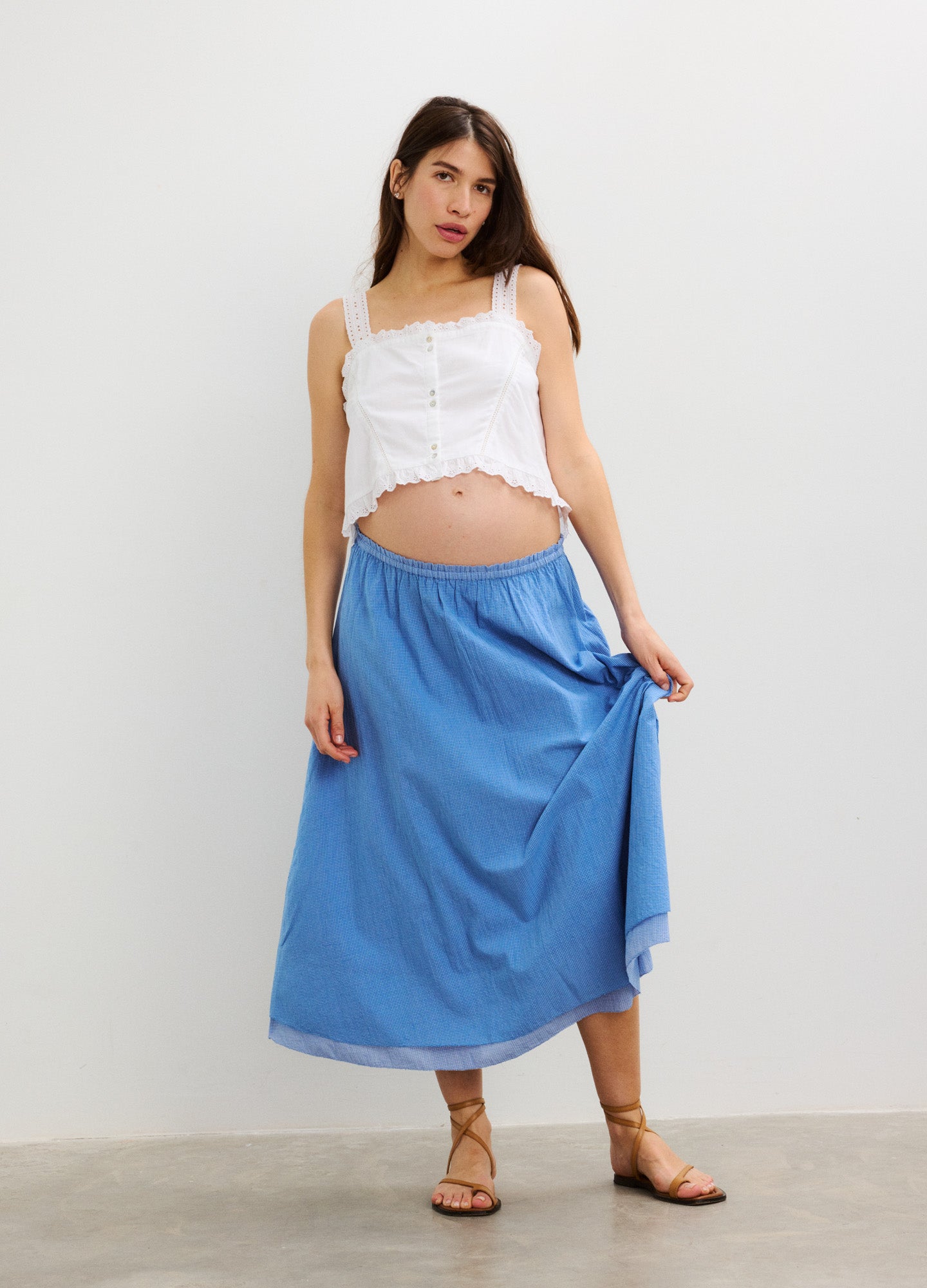 Blue maternity skirt with soft elastic waistband, flowy midi length, worn by pregnant model.