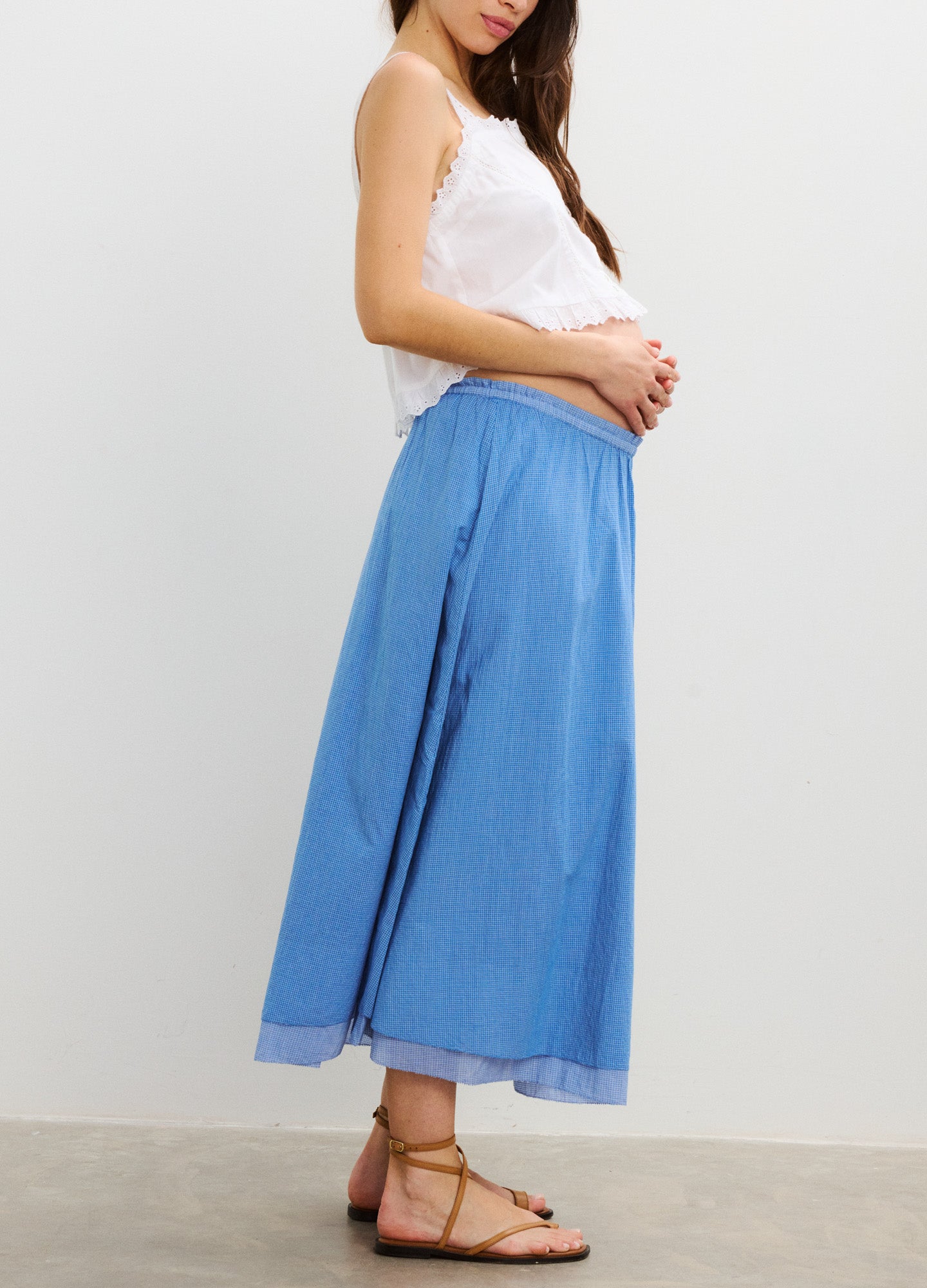 Light blue midi maternity skirt with flowy fabric and elastic waist, styled for pregnancy.