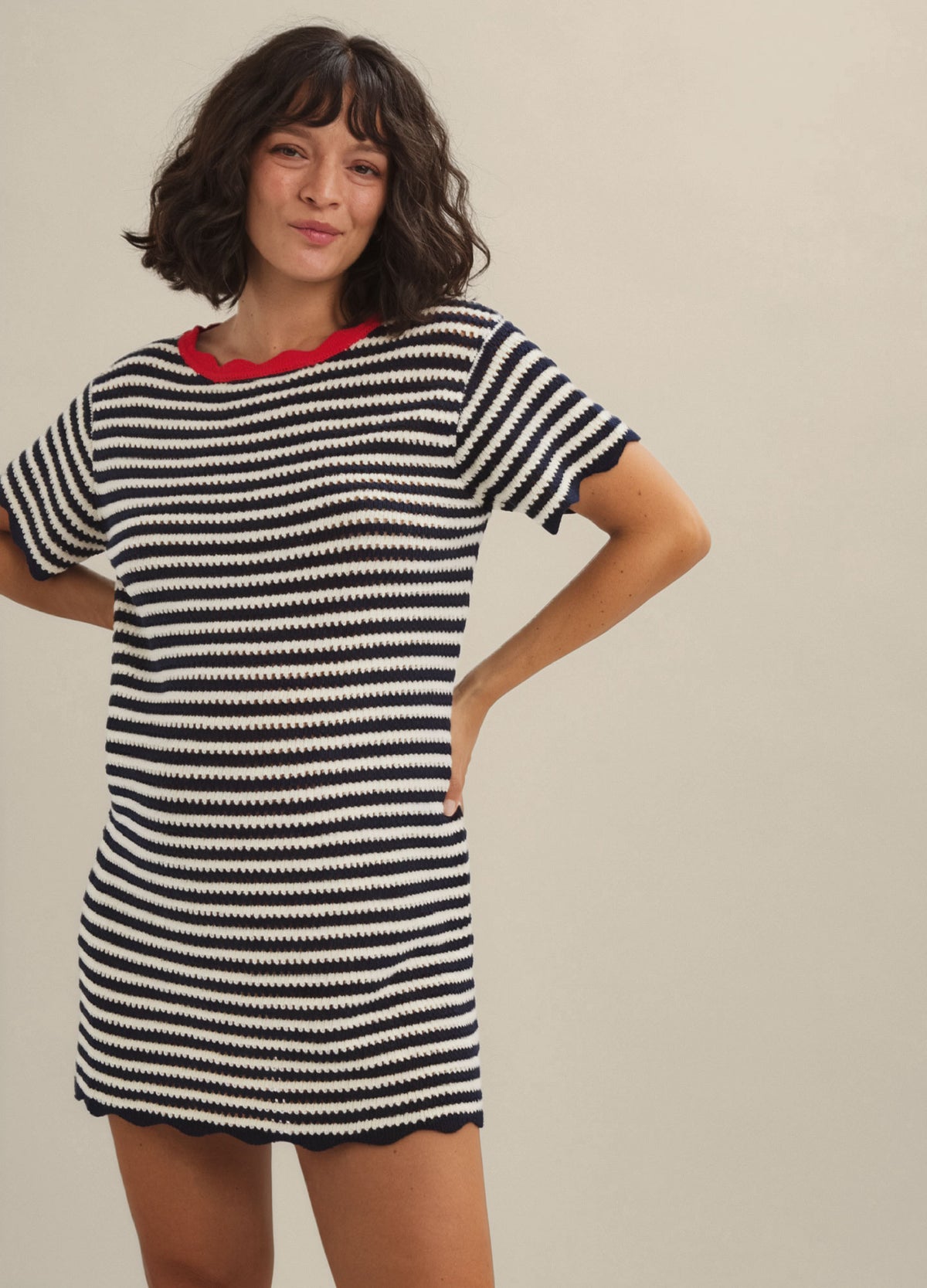 Black and white striped short-sleeve mini dress with red neckline, designed for maternity wear.