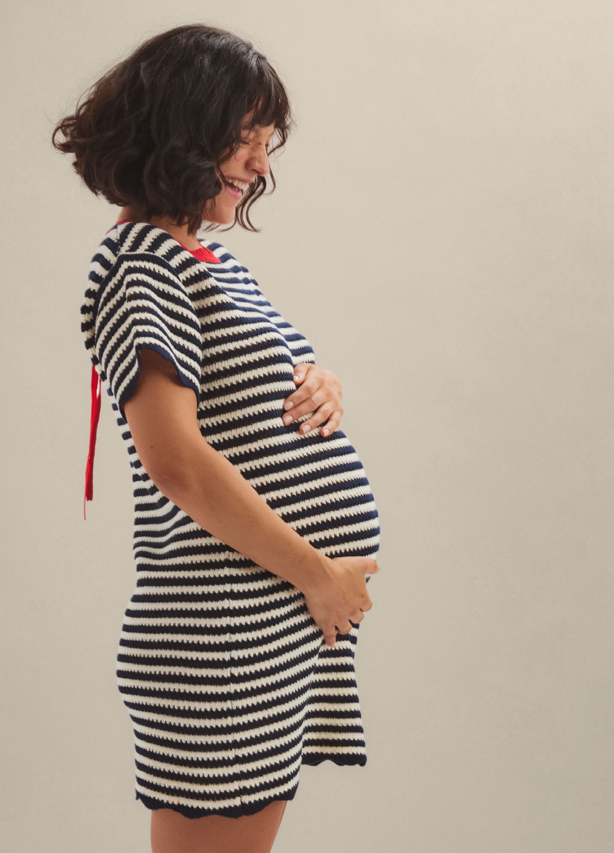 Black and white striped short-sleeve maternity mini dress with a relaxed fit and side ruching.