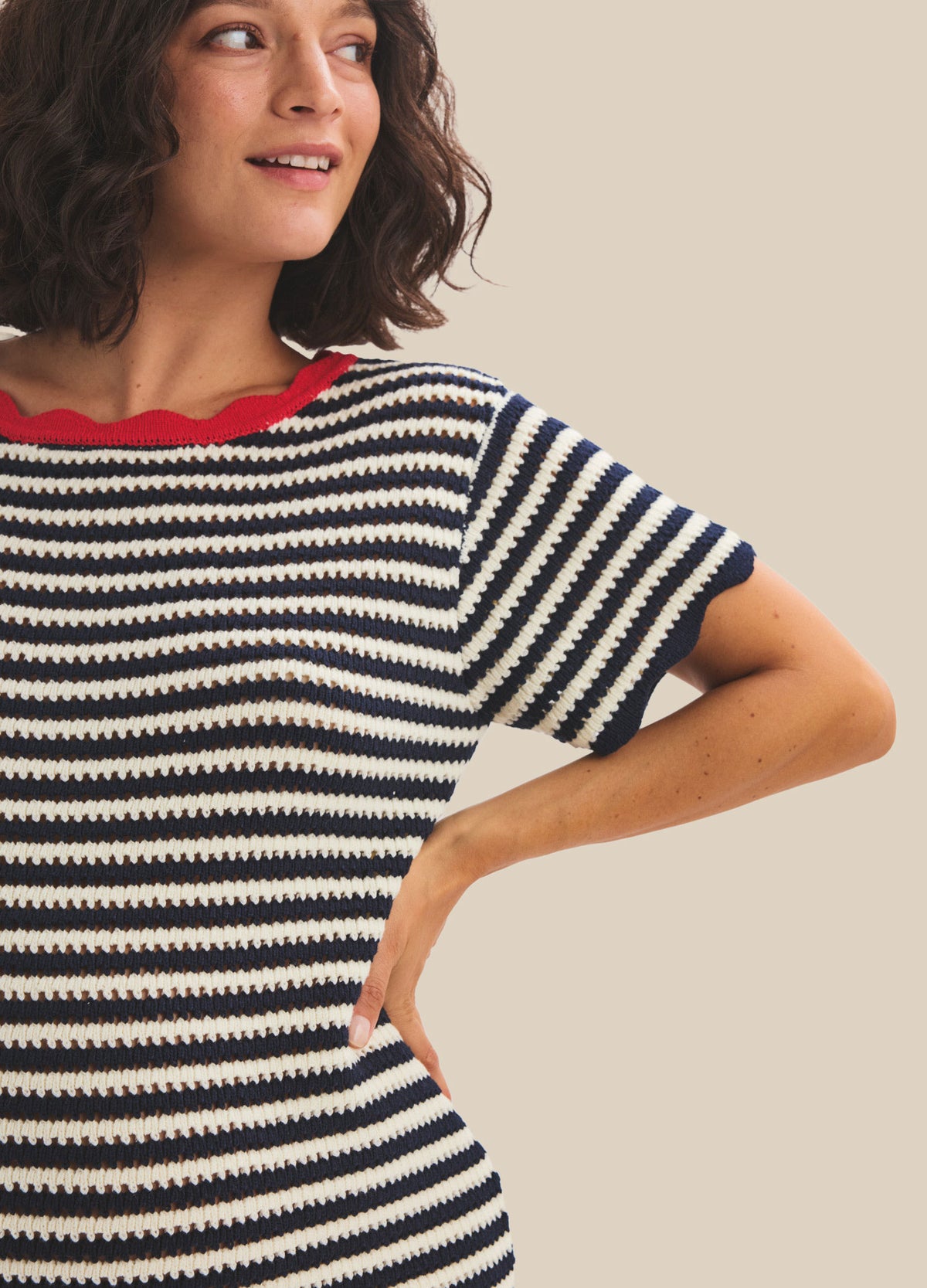 Black and white striped knit maternity mini dress with red trim on neckline and short sleeves.