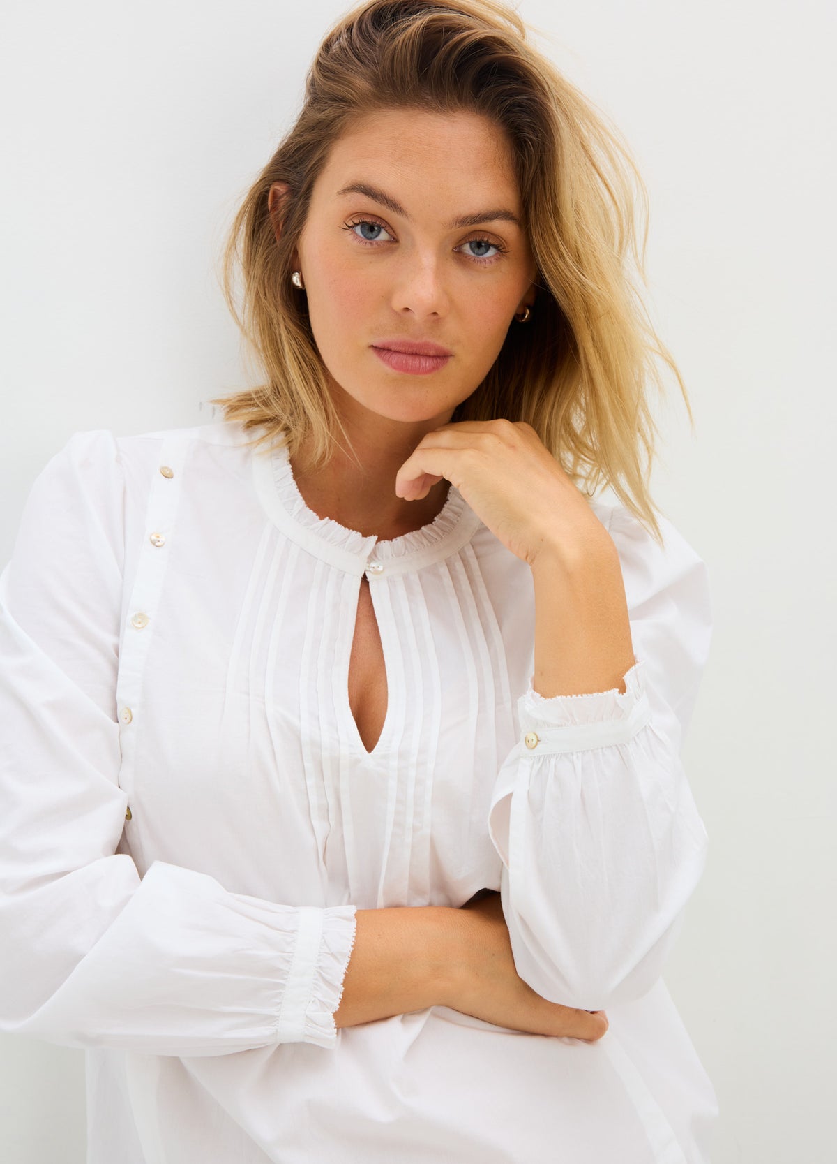 White maternity nursing blouse with long puff sleeves, button details, and keyhole neckline.