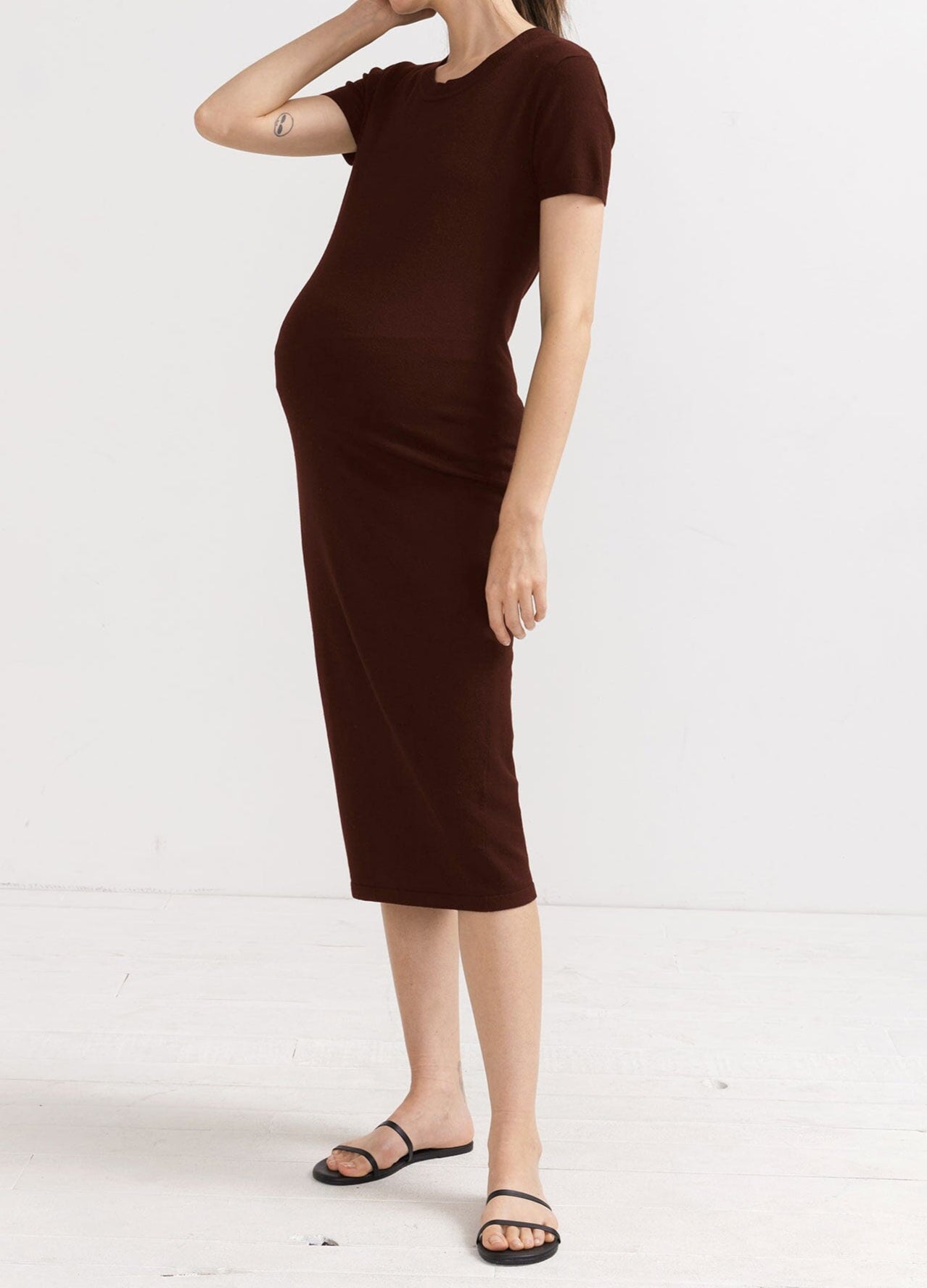 The Eliza Dress POS - Black short-sleeve maternity dress with nursing-friendly design and fitted silhouette, styled with tall black boots.