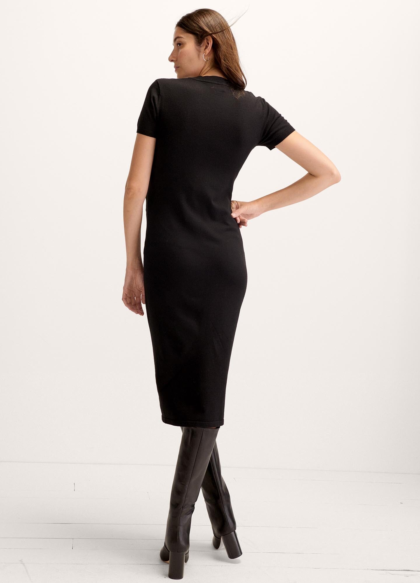 The Eliza Dress POS - Black short-sleeve maternity dress with nursing-friendly design and fitted silhouette, styled with tall black boots.