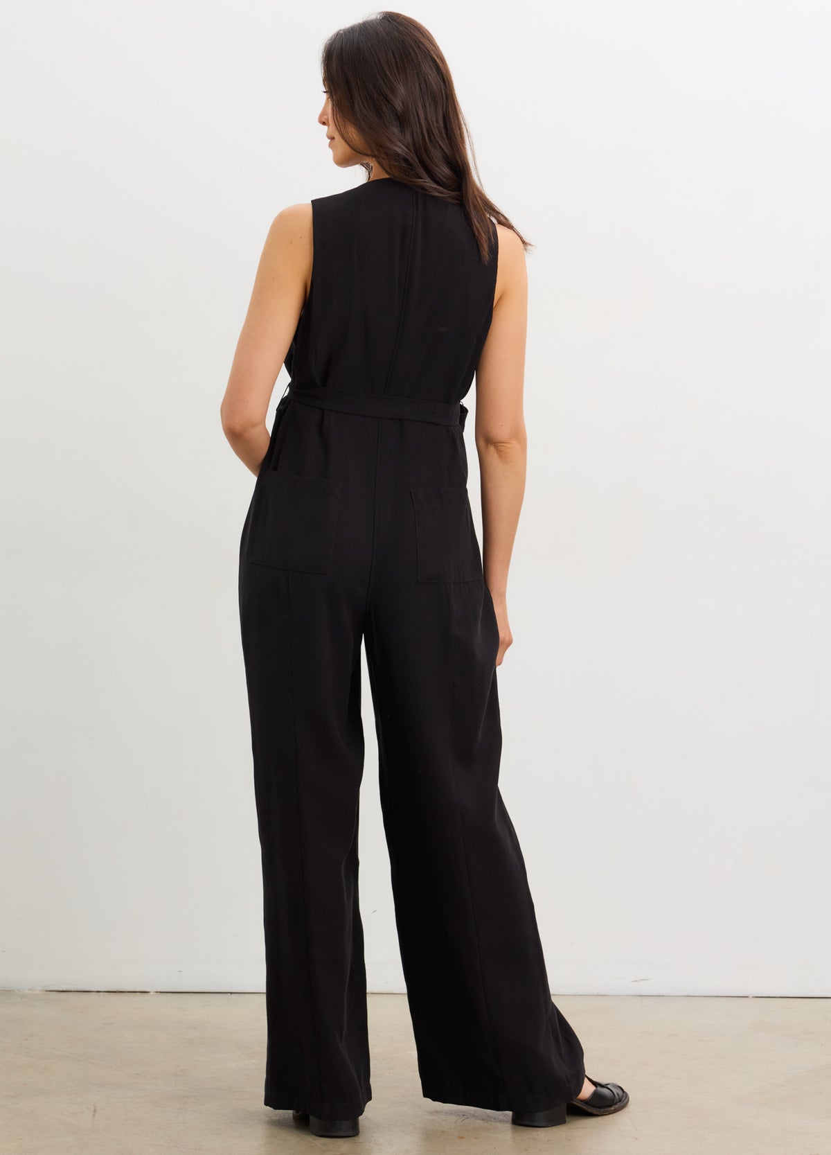 The Elliot Jumpsuit - Black sleeveless maternity jumpsuit with V-neck, nursing-friendly buttons, and a tie waist designed for pregnancy and.