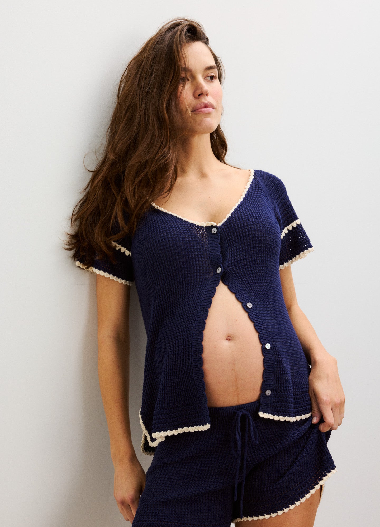 Navy blue maternity crochet shorts with white trim and drawstring waist, paired with matching button-up top with white trim.