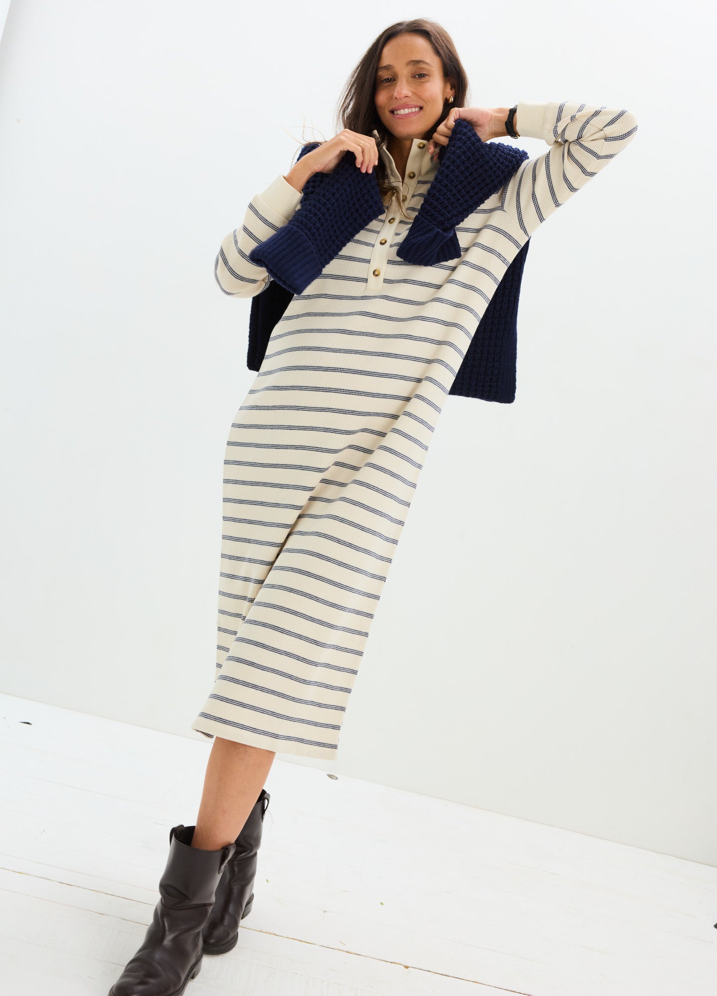 Cream and navy striped waffle knit midi nursing dress with long sleeves and a relaxed fit, styled with a navy sweater draped