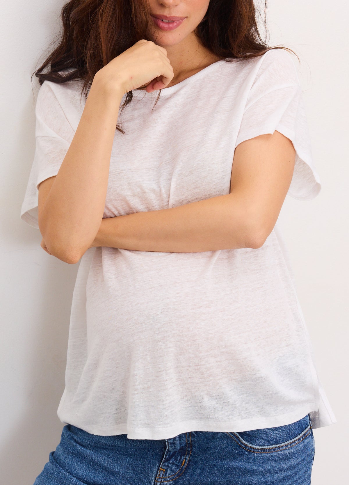 Soft white linen maternity tee with short sleeves and relaxed fit over pregnant belly.