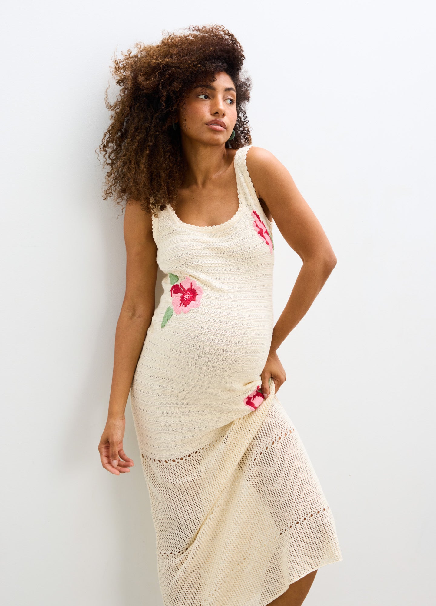 Cream crochet maternity dress with floral embroidery and sleeveless design.