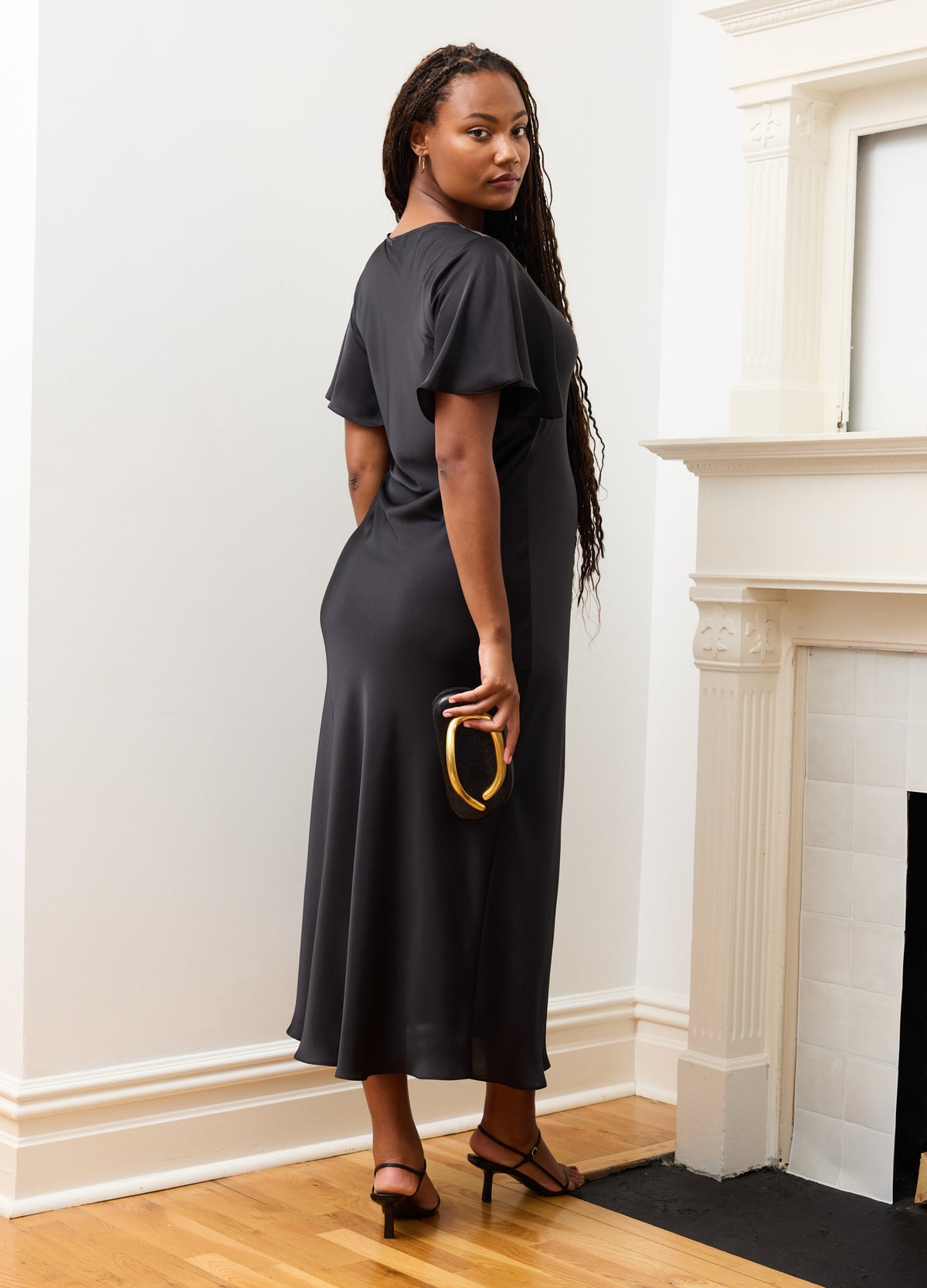 Black maternity dress with short flutter sleeves and fitted waist, worn by pregnant model.