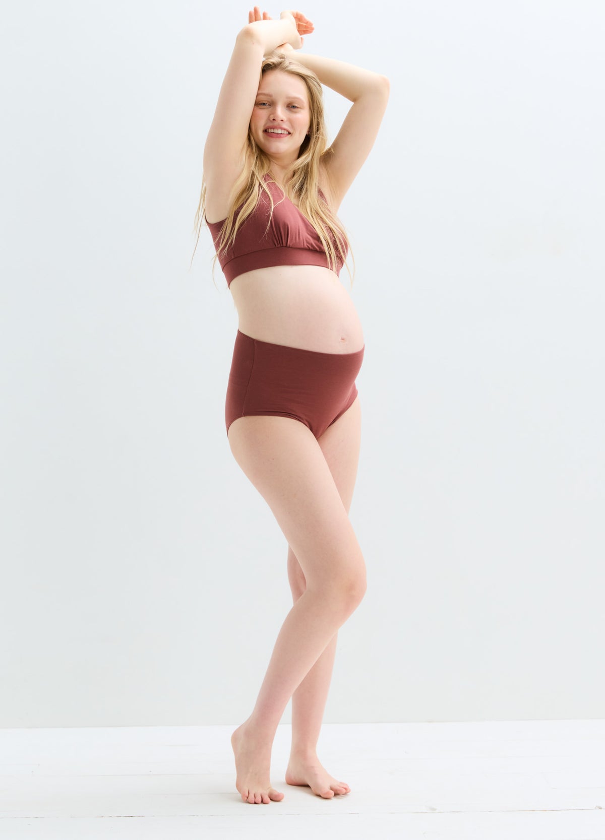 Maternity high-waisted brown briefs with full belly coverage on pregnant model.