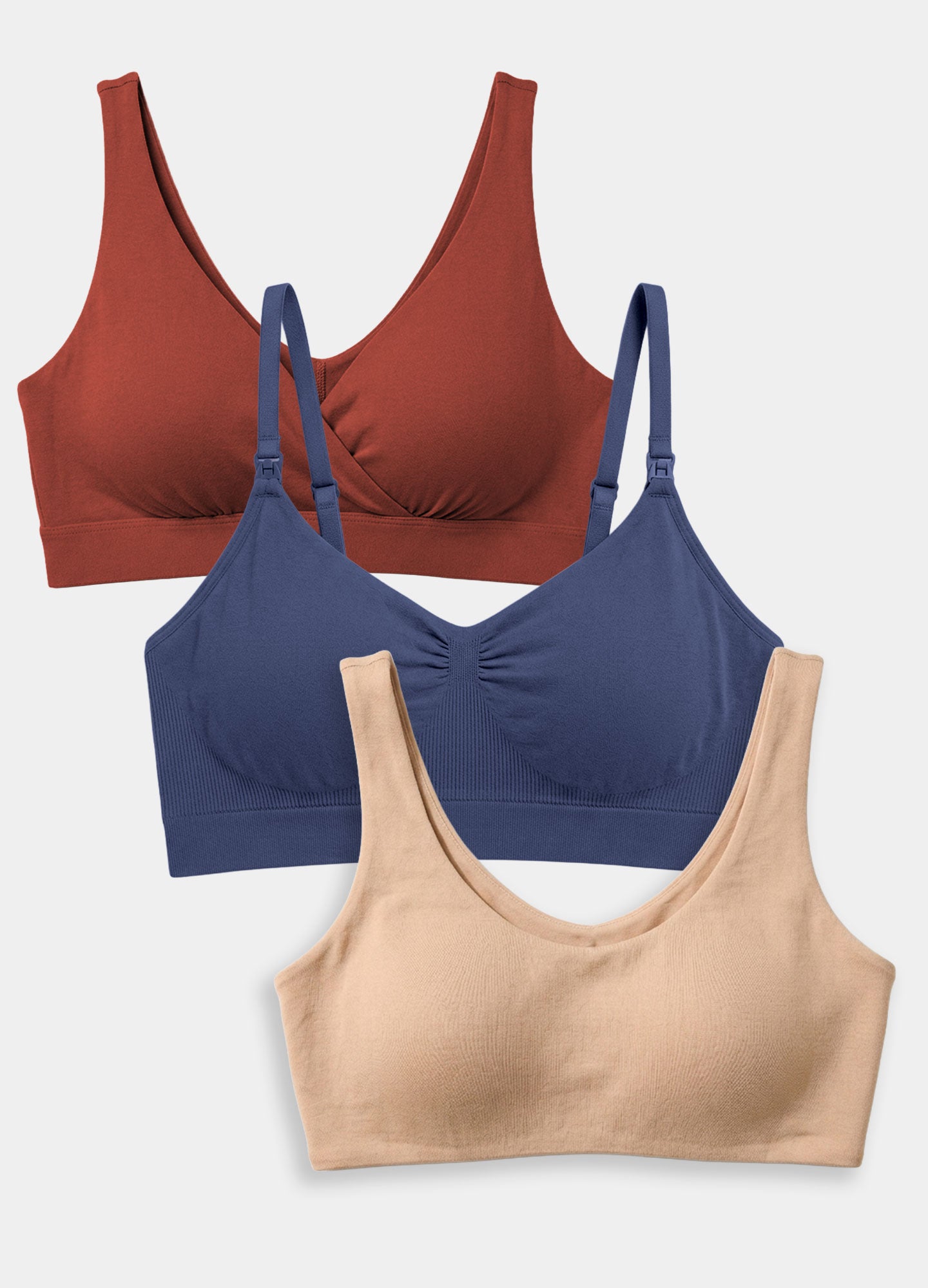 Set of three maternity bras in rust, navy, and beige with wireless, seamless design and adjustable straps.