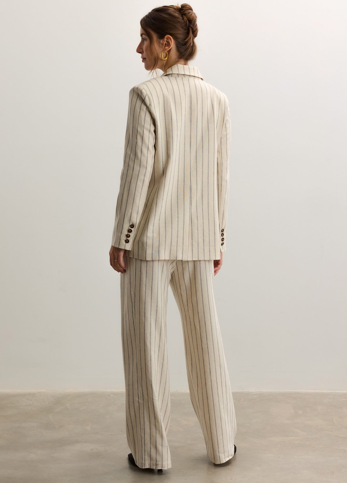 Beige pinstripe tailored twill blazer with long sleeves, worn with matching wide-leg trousers, maternity fit.