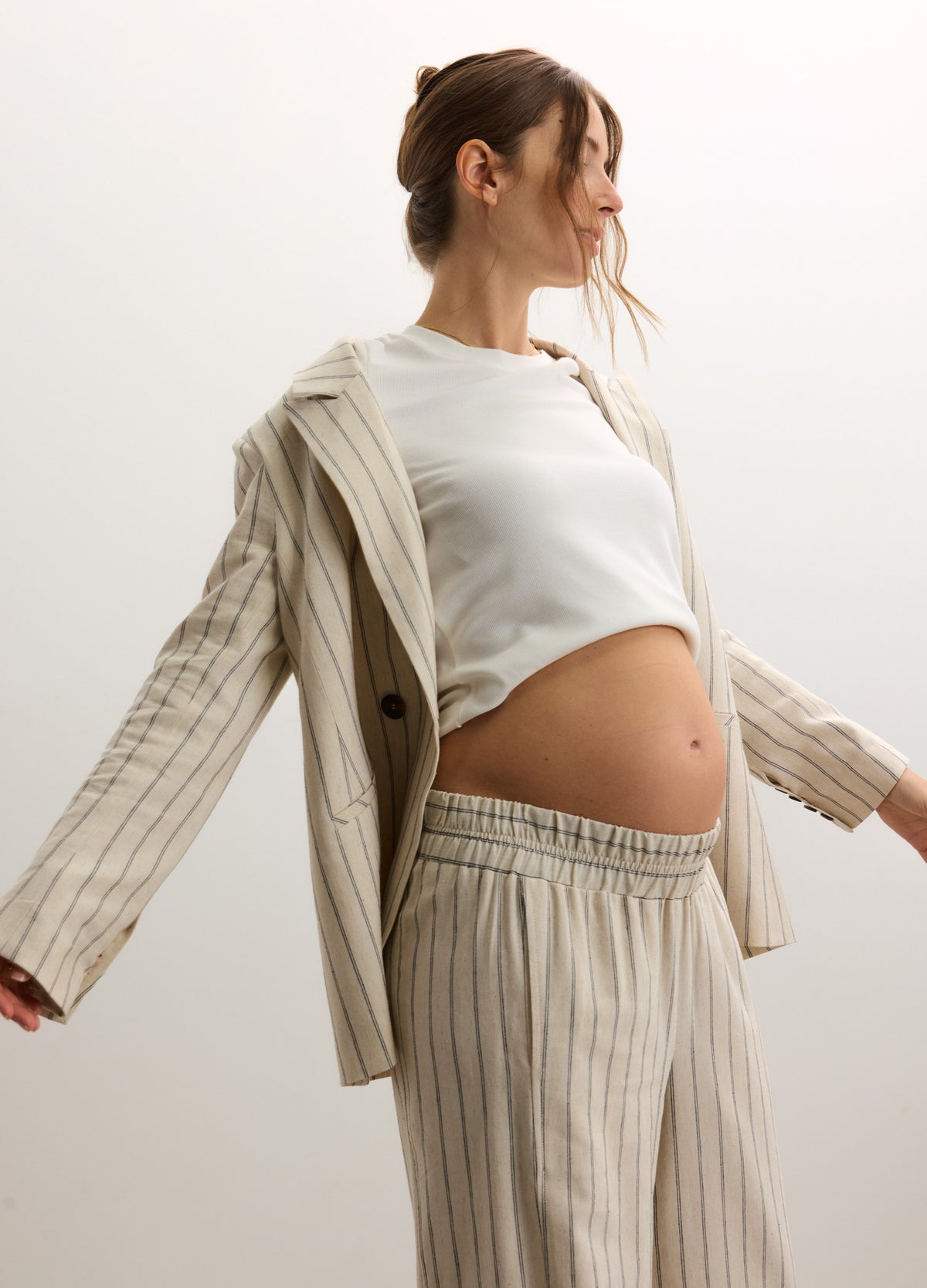Light beige pinstripe soft twill maternity blazer paired with matching elastic waist pants and a white cropped top.