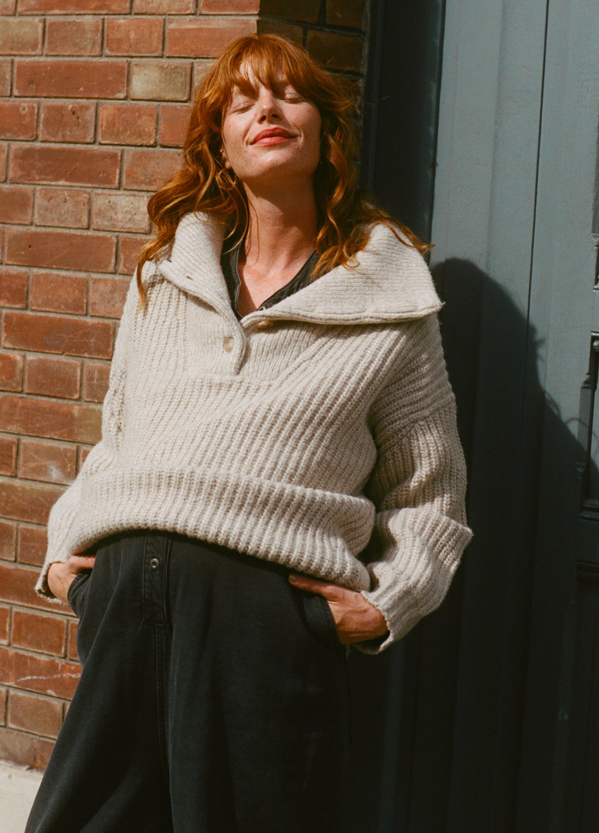 Creamy off-white ribbed knit sweater with oversized cowl neck and relaxed fit, styled for maternity wear.