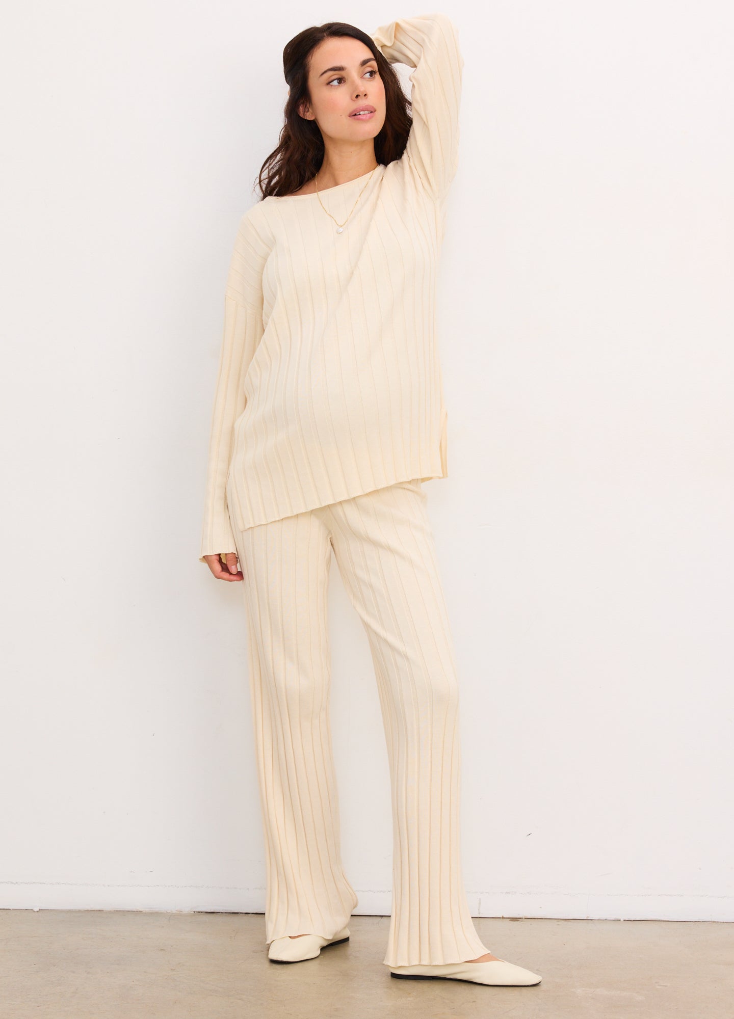 Cream ribbed cotton maternity pants with a relaxed fit paired with a matching long-sleeve top.