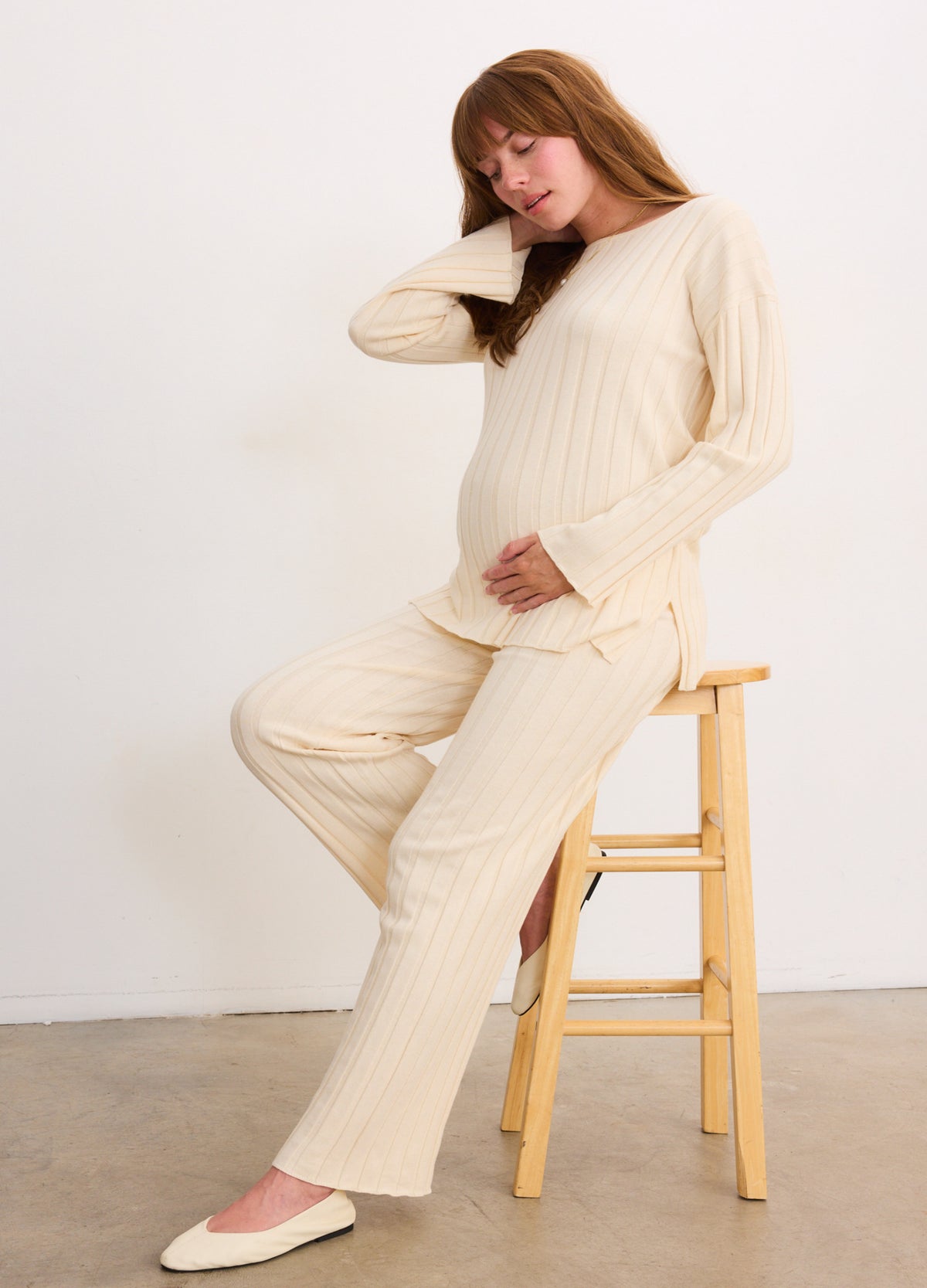 Cream-colored ribbed maternity cotton pants with a matching long-sleeve top, relaxed fit.