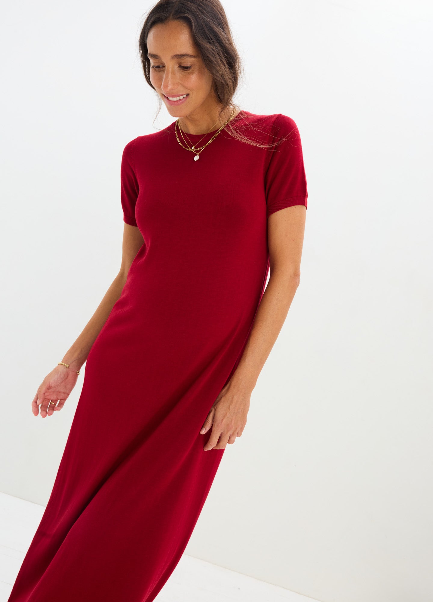 Red knit maternity dress with short sleeves and fitted silhouette designed for pregnant women.