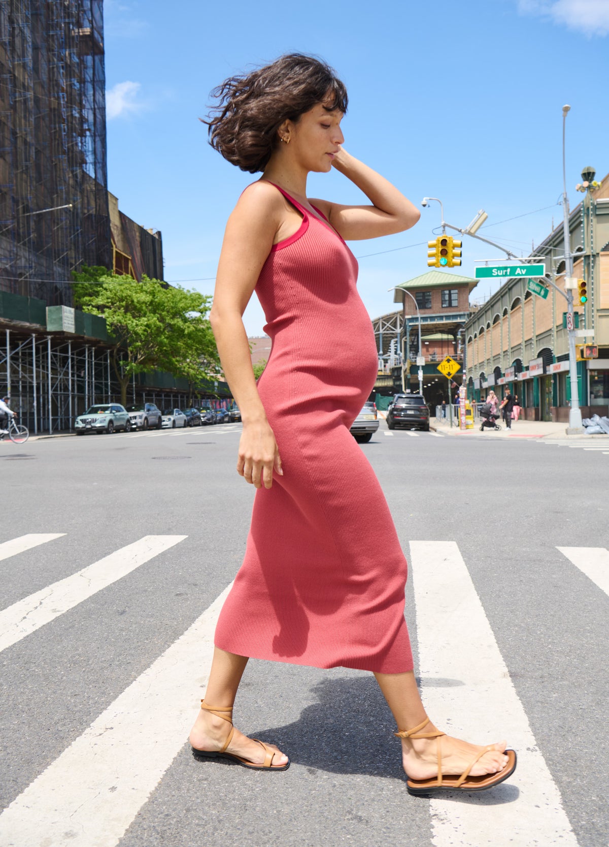 Rose pink sleeveless maternity dress with scoop neckline and fitted silhouette, worn with flat sandals.
