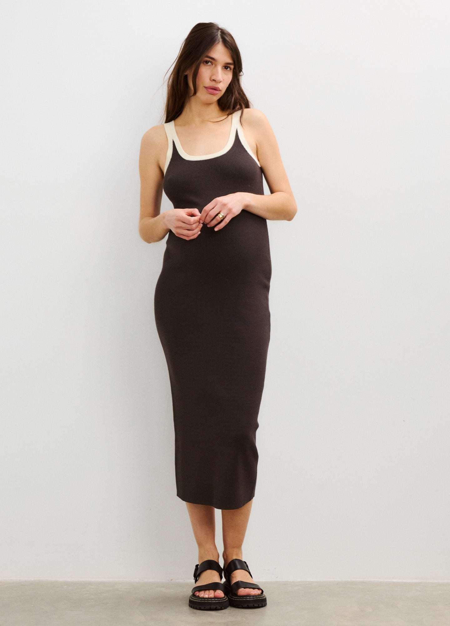 Black sleeveless maternity dress with white trim, fitted silhouette, and midi length.