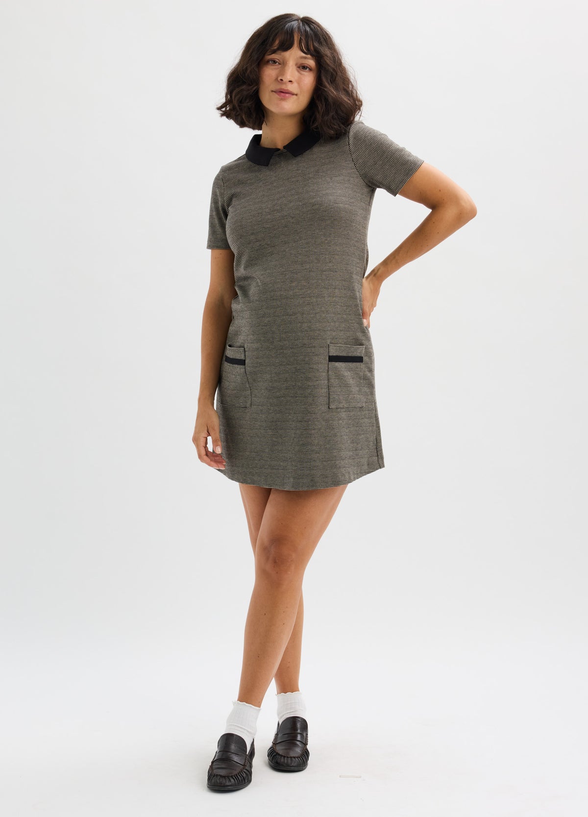 Gray short-sleeve maternity mini dress with subtle check pattern and black trim pockets.