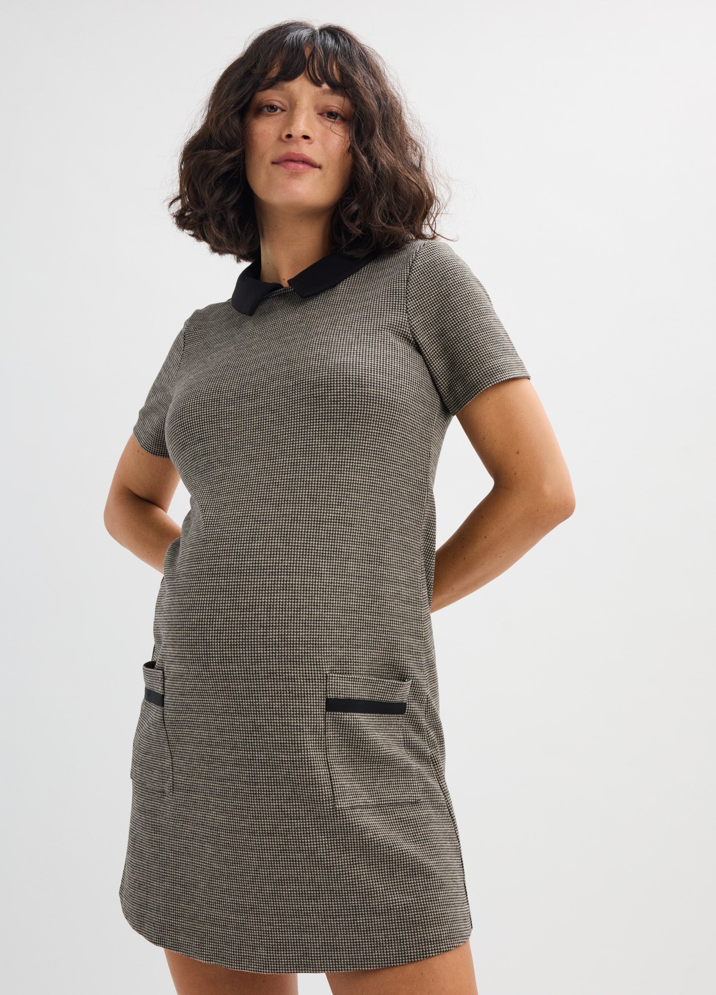 Grey textured maternity mini dress with short sleeves, black collar, and front pockets.