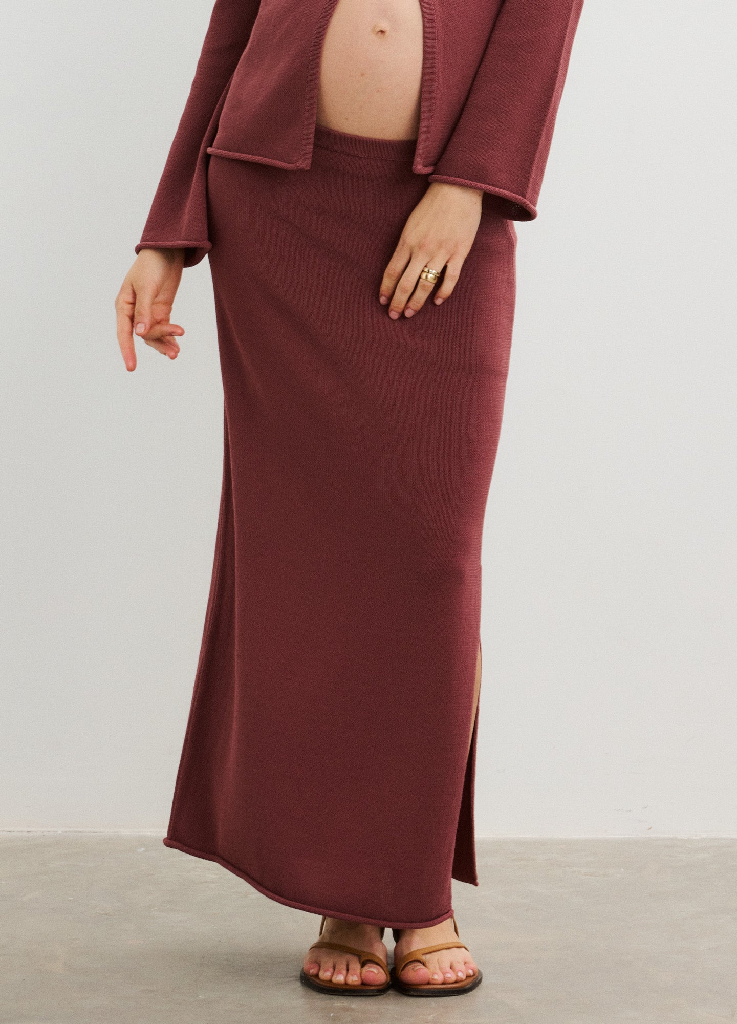 Burgundy maternity maxi skirt with side slit in soft, stretchy fabric designed for pregnant women.
