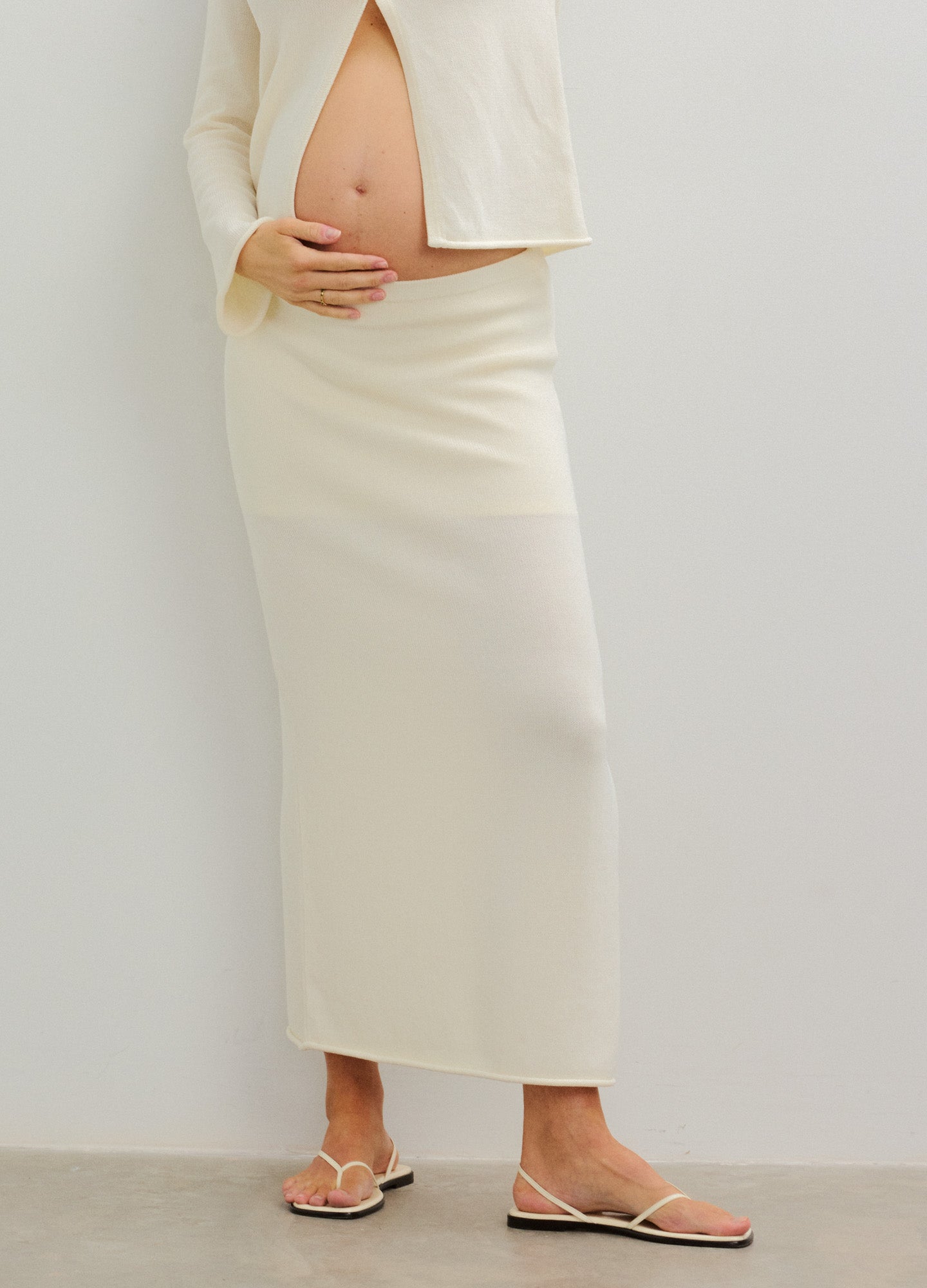 Cream-colored, stretchy maternity skirt with a straight, ankle-length design.
