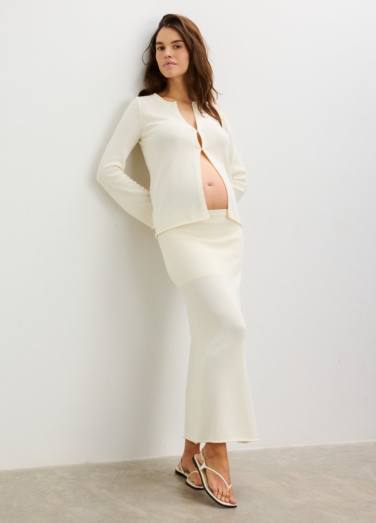 Cream-colored maternity top with long sleeves and buttons, paired with a matching skirt.