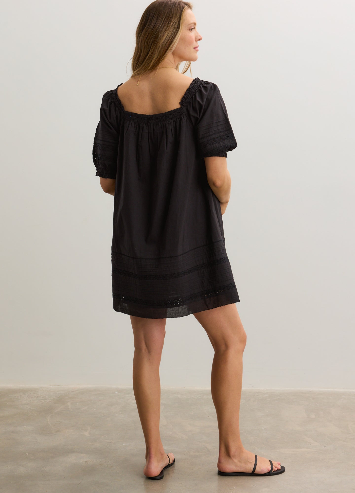 Black maternity mini dress with puff sleeves, square neckline, and relaxed fit perfect for nursing.