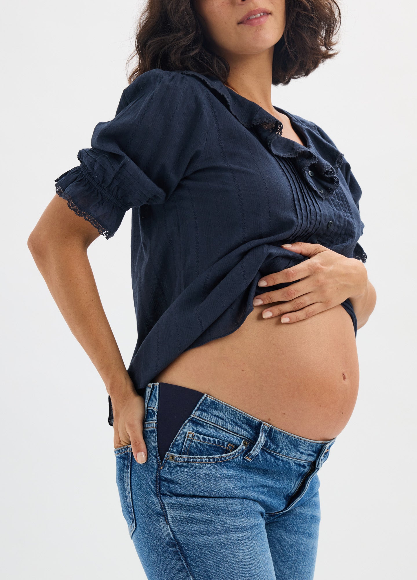 Navy blue maternity nursing blouse with ruched sleeves and scrunched front detailing, worn over jeans on pregnant model.