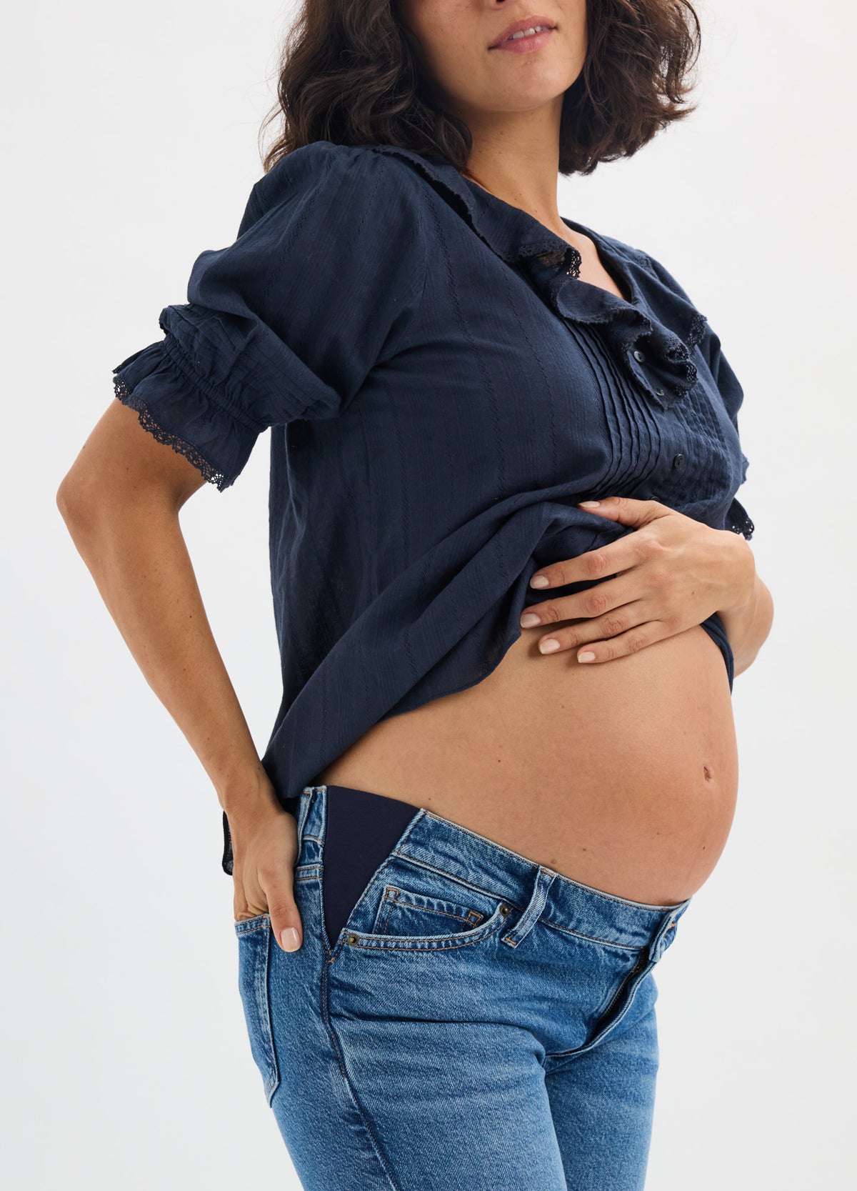 Navy blue maternity nursing blouse with ruched sleeves and scrunched front detailing, worn over jeans on pregnant model.