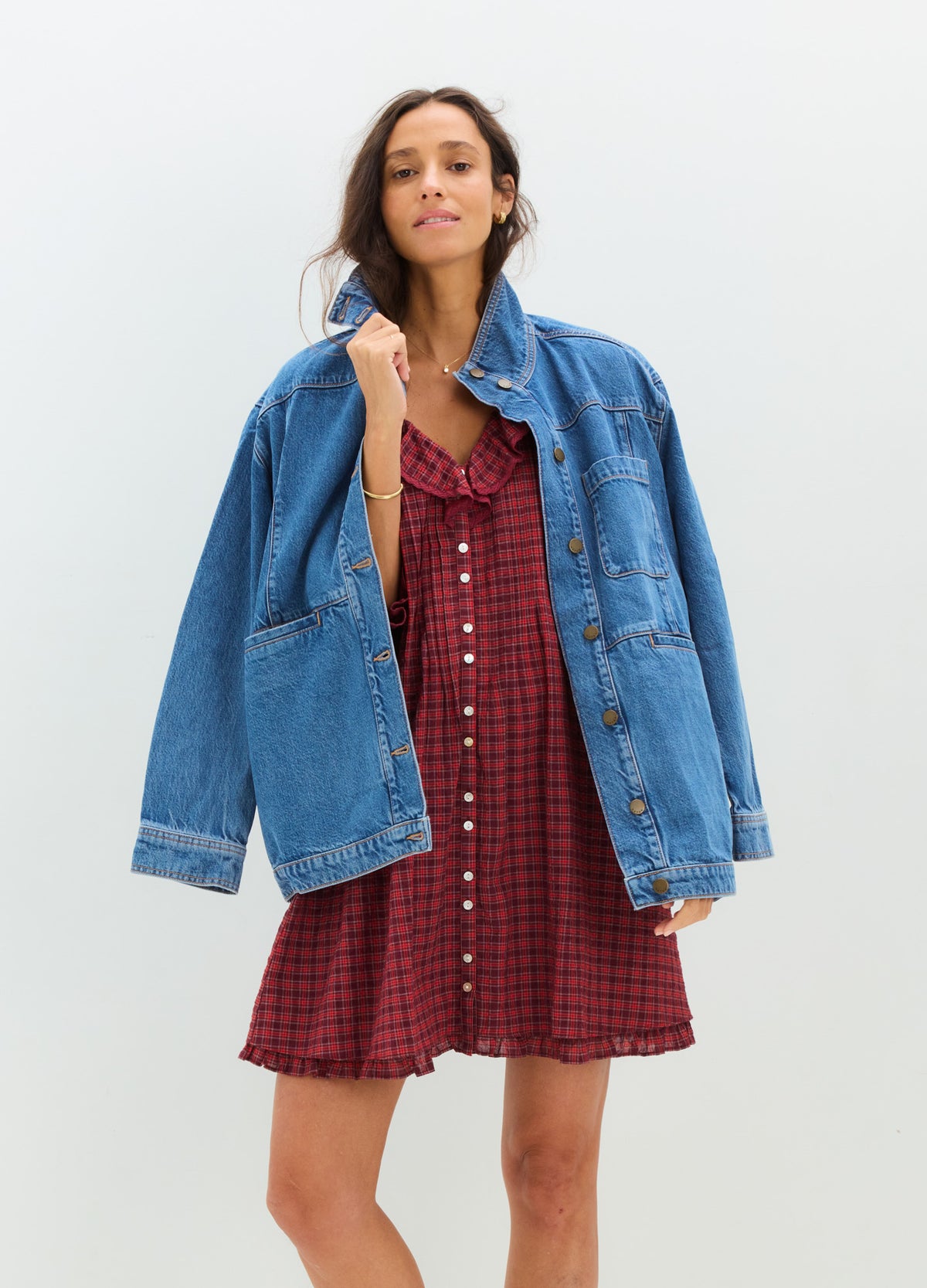Red plaid maternity mini dress with front buttons and ruffled hem, styled with oversized blue denim jacket.