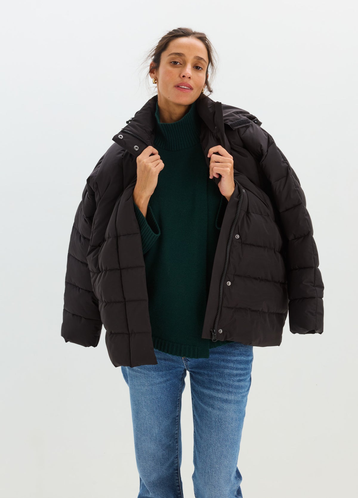 Black oversized quilted puffer jacket with a high collar, snap front, and roomy sleeves.