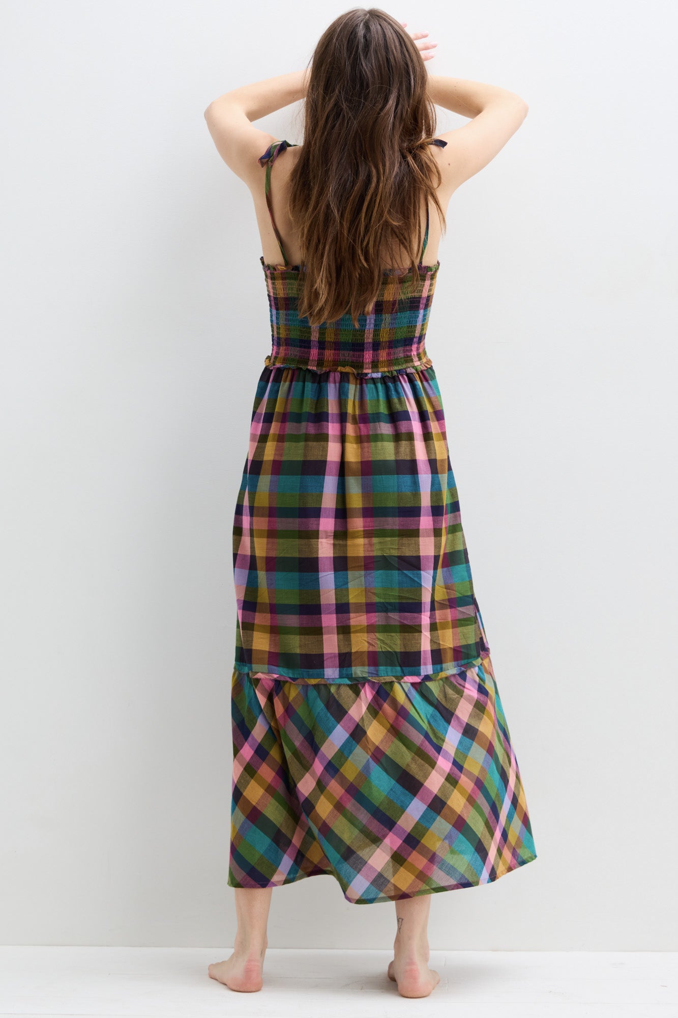 Sleeveless maternity dress with multicolor plaid pattern and tiered skirt, ankle length.