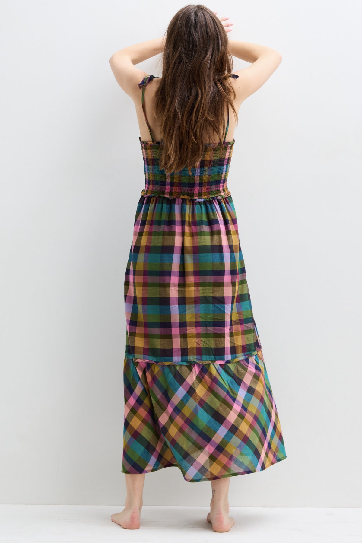 Sleeveless maternity dress with multicolor plaid pattern and tiered skirt, ankle length.