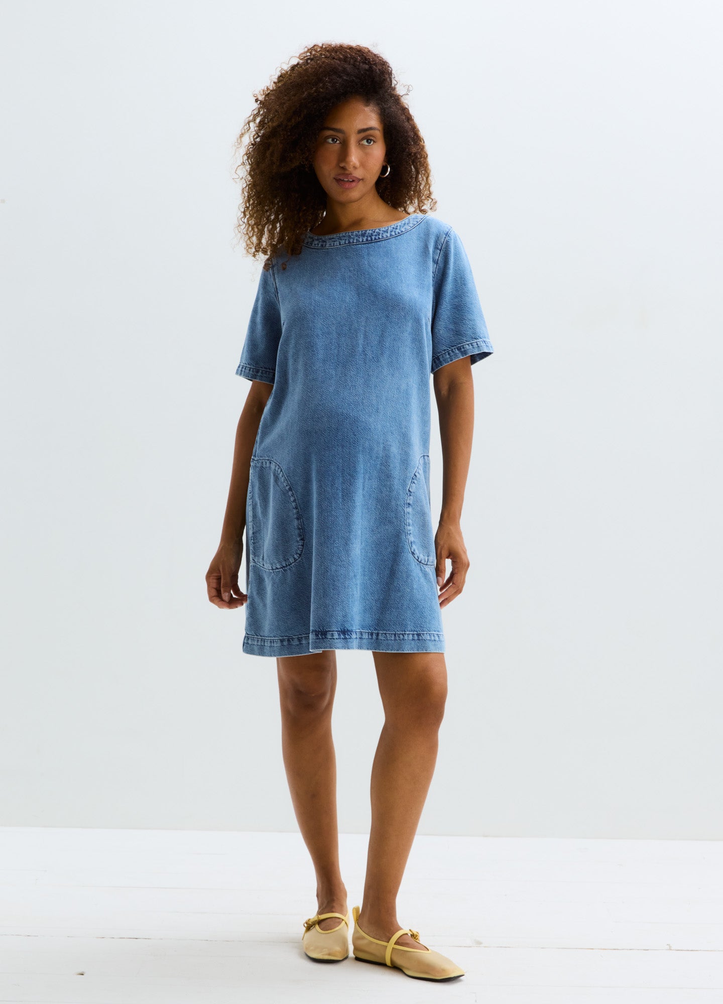 Light blue short-sleeve maternity denim dress with a relaxed fit and knee-length hem.