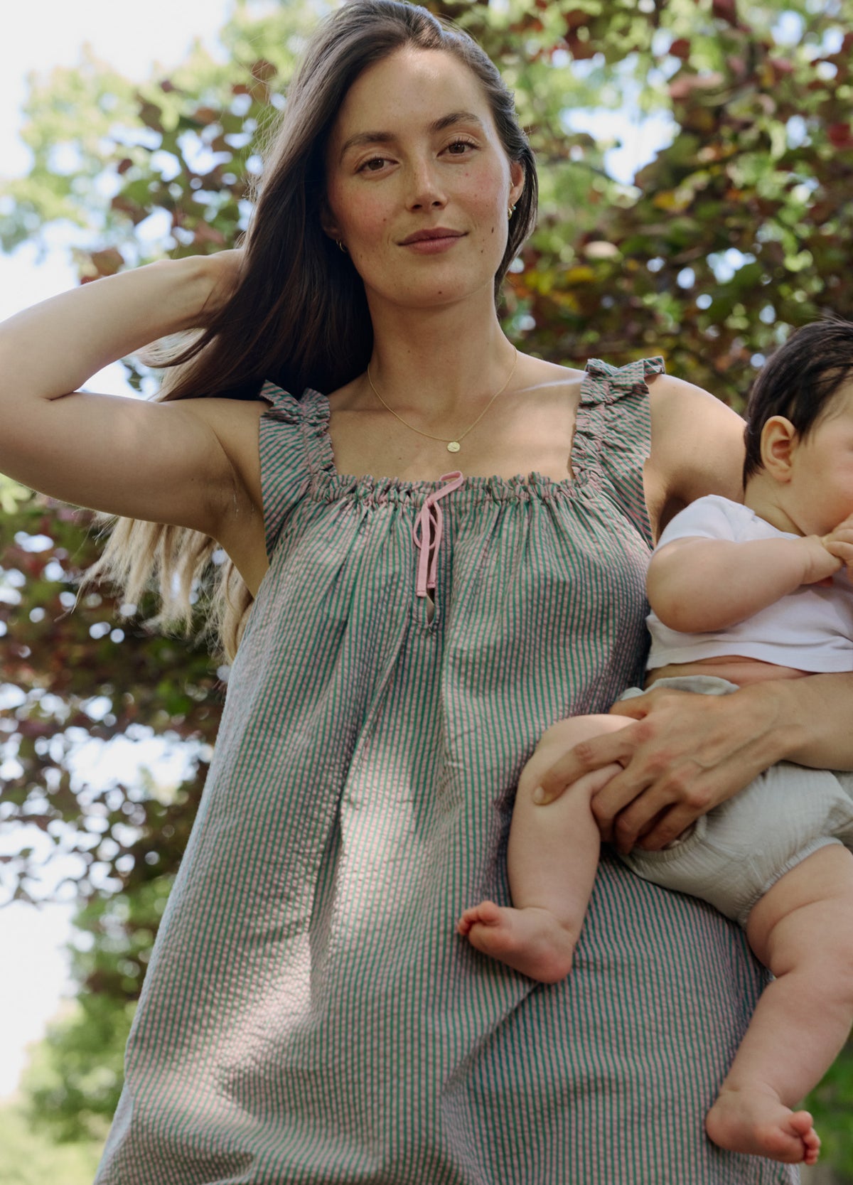 Light green maternity nursing mini dress with smocked bust and adjustable tie front straps.