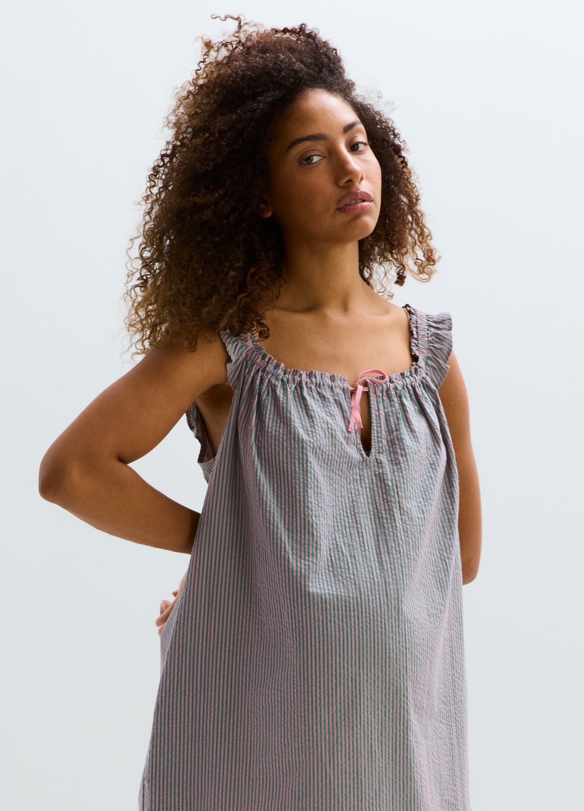 Gray sleeveless maternity mini dress with gathered neckline and ruffle straps, loose fit.